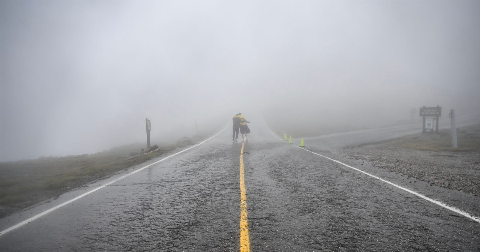 Two runners helping each other down Mount Washington in the fog