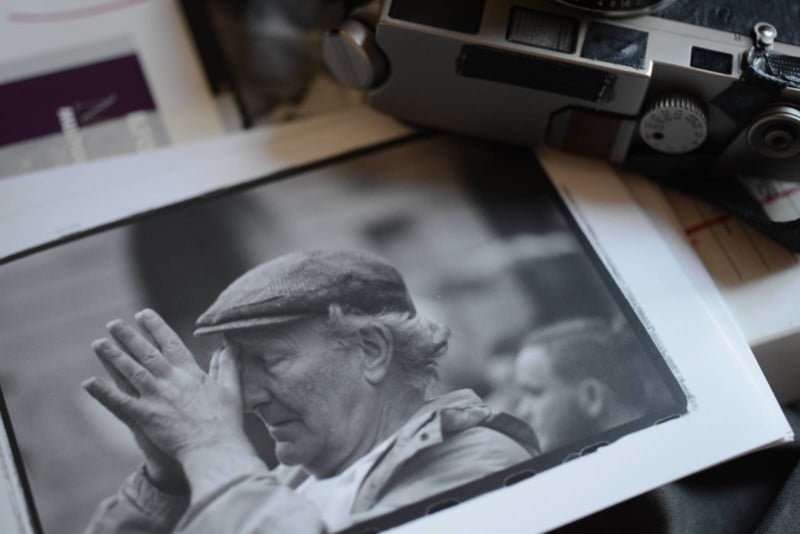 A black and white photo print of an older man on a tabletop