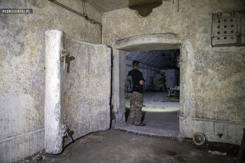 An urban explorer standing in the doorway of an underground ammo factory