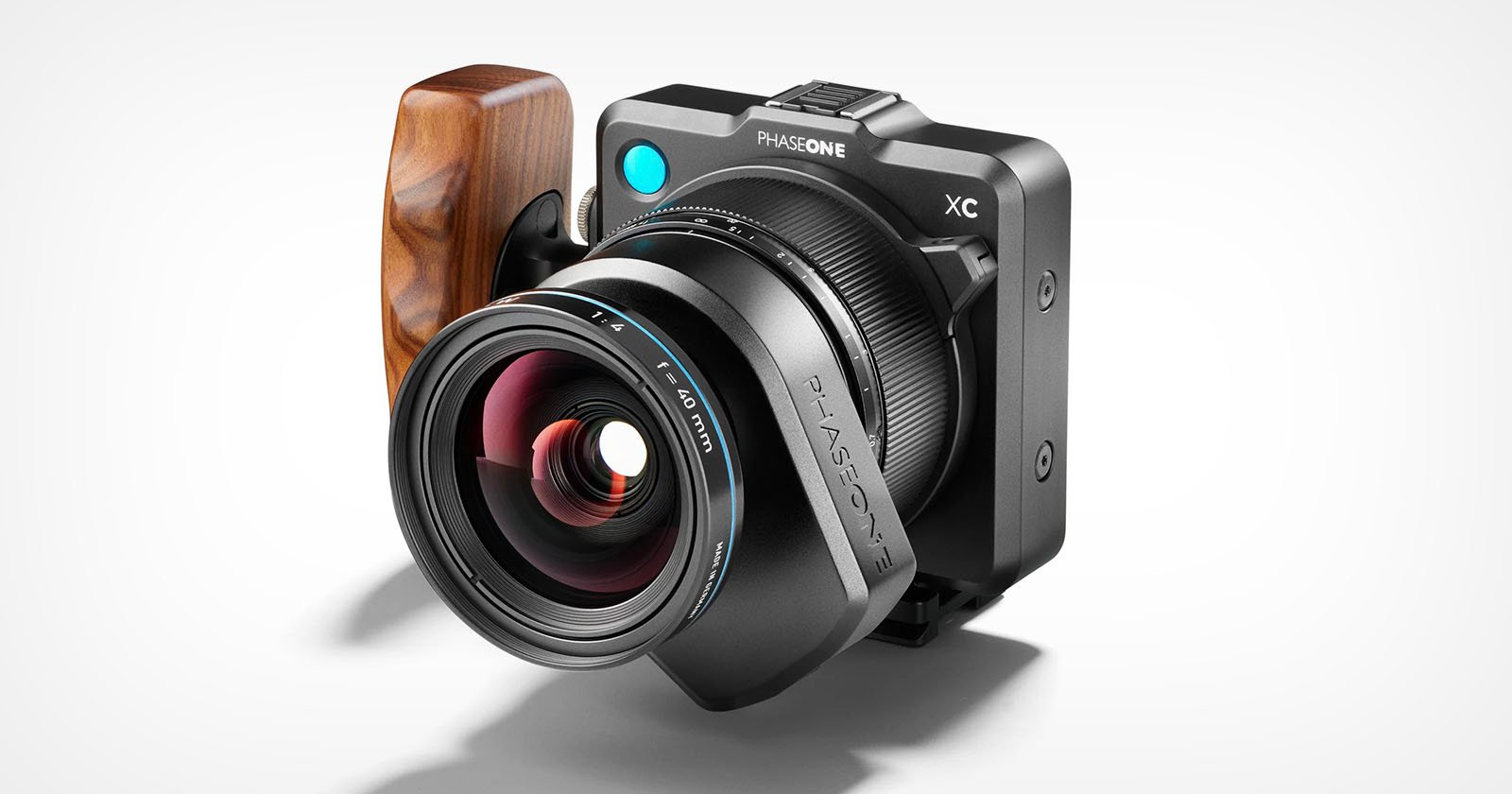 A high-end digital camera with a wooden grip is shown against a white background. The camera features a large lens, labeled Phase One with XT prominently displayed at the top. The design is sleek with a combination of black and wooden elements.