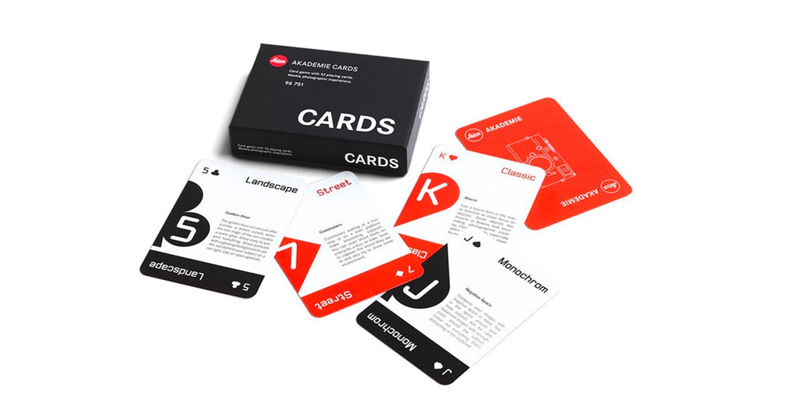 A set of playing cards with a black box labeled CARDS. The cards are spread out, featuring minimalist designs with categories like Landscape, Street, Classic, and Monochrome in black, white, and red colors.