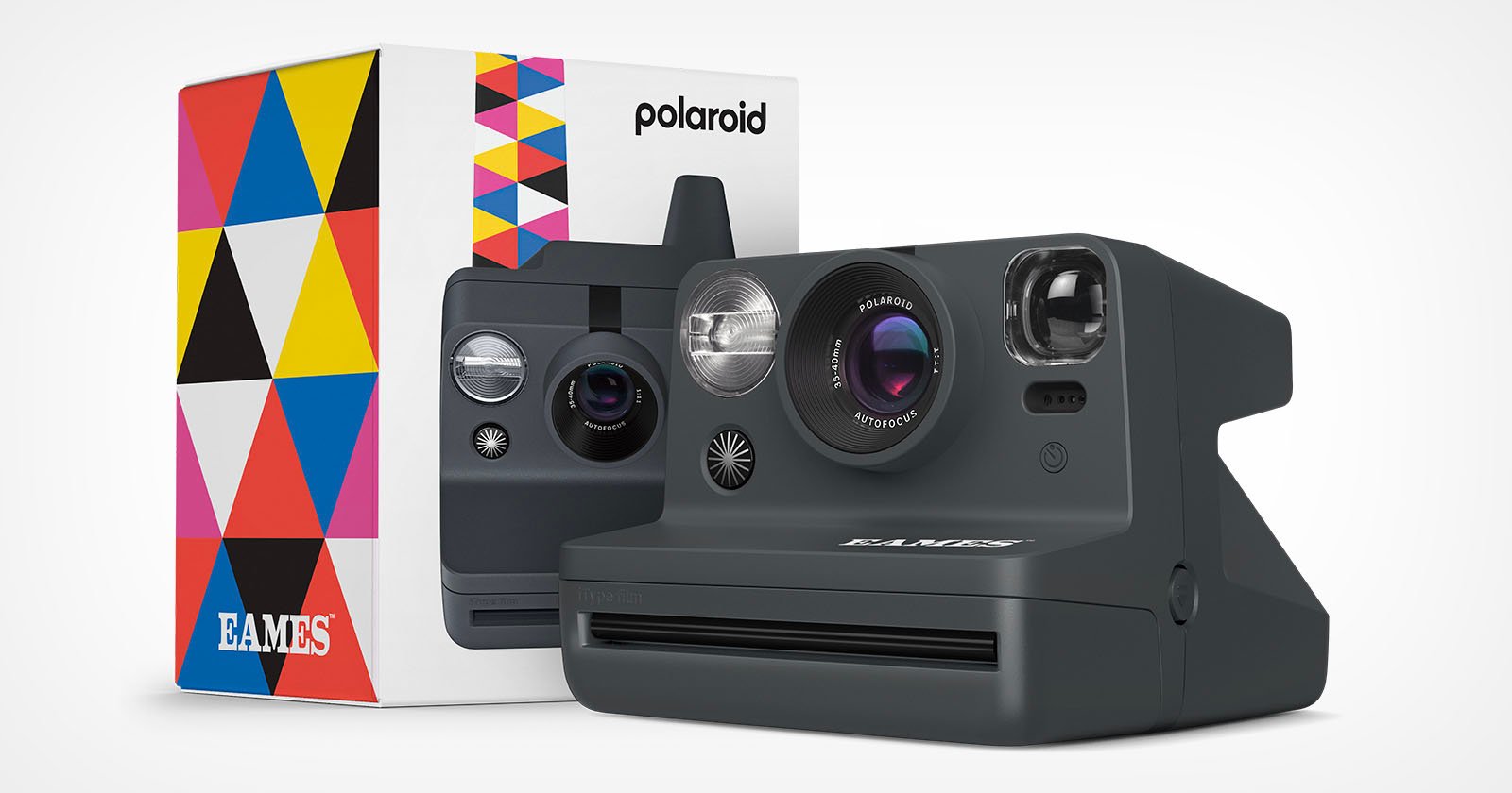 A Polaroid instant camera with a sleek black design, placed in front of its colorful, geometric-patterned box. The box features the Polaroid logo and the name Eames. The camera has a large lens, viewfinder, flash, and the Polaroid logo on the front.