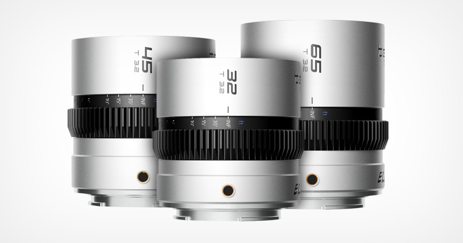 Three silver camera lenses labeled 45, 32, and 65 are displayed upright against a white background. Each lens has a black gear ring and engraved aperture markings.