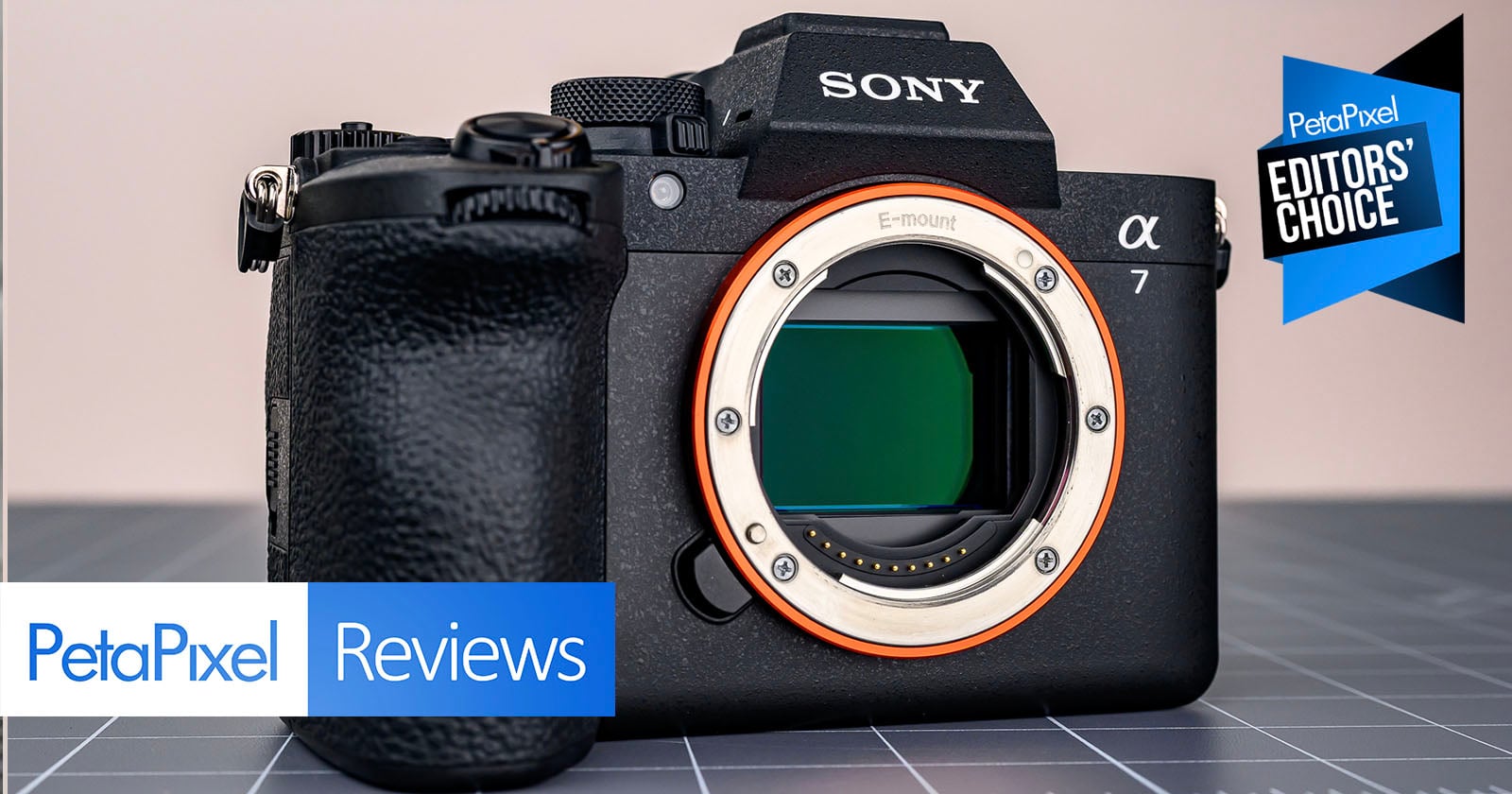 A Sony Alpha 7 camera body is displayed on a gray grid surface. PetaPixel Reviews and Editors’ Choice banners appear on the image, indicating a positive camera review.