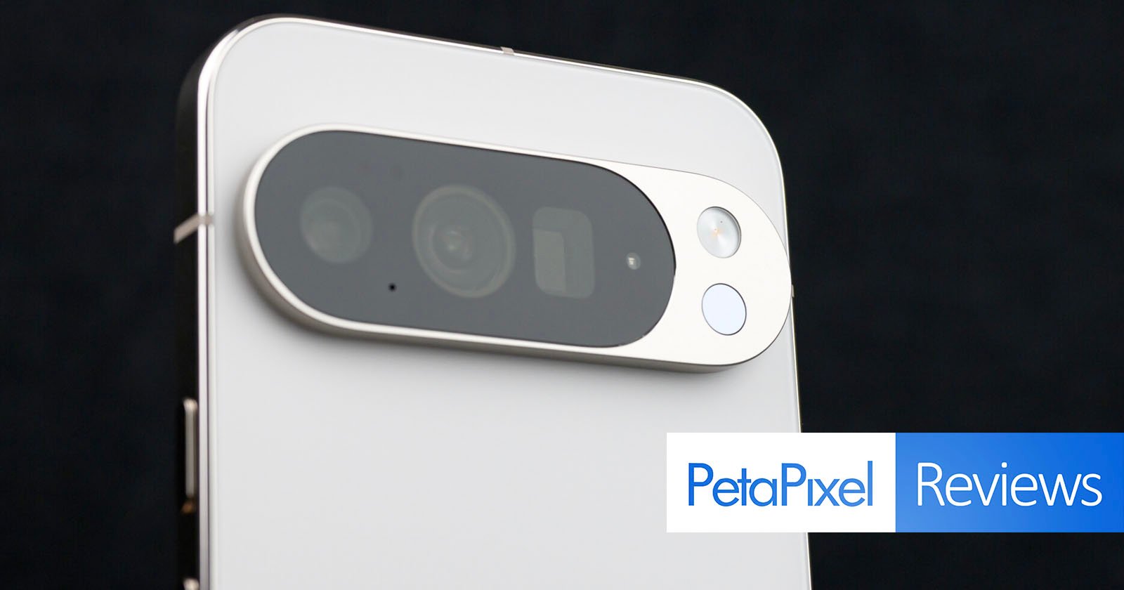 Close-up of the rear camera module on a white smartphone with three lenses and a flash, featuring a PetaPixel Reviews banner in the bottom right corner.