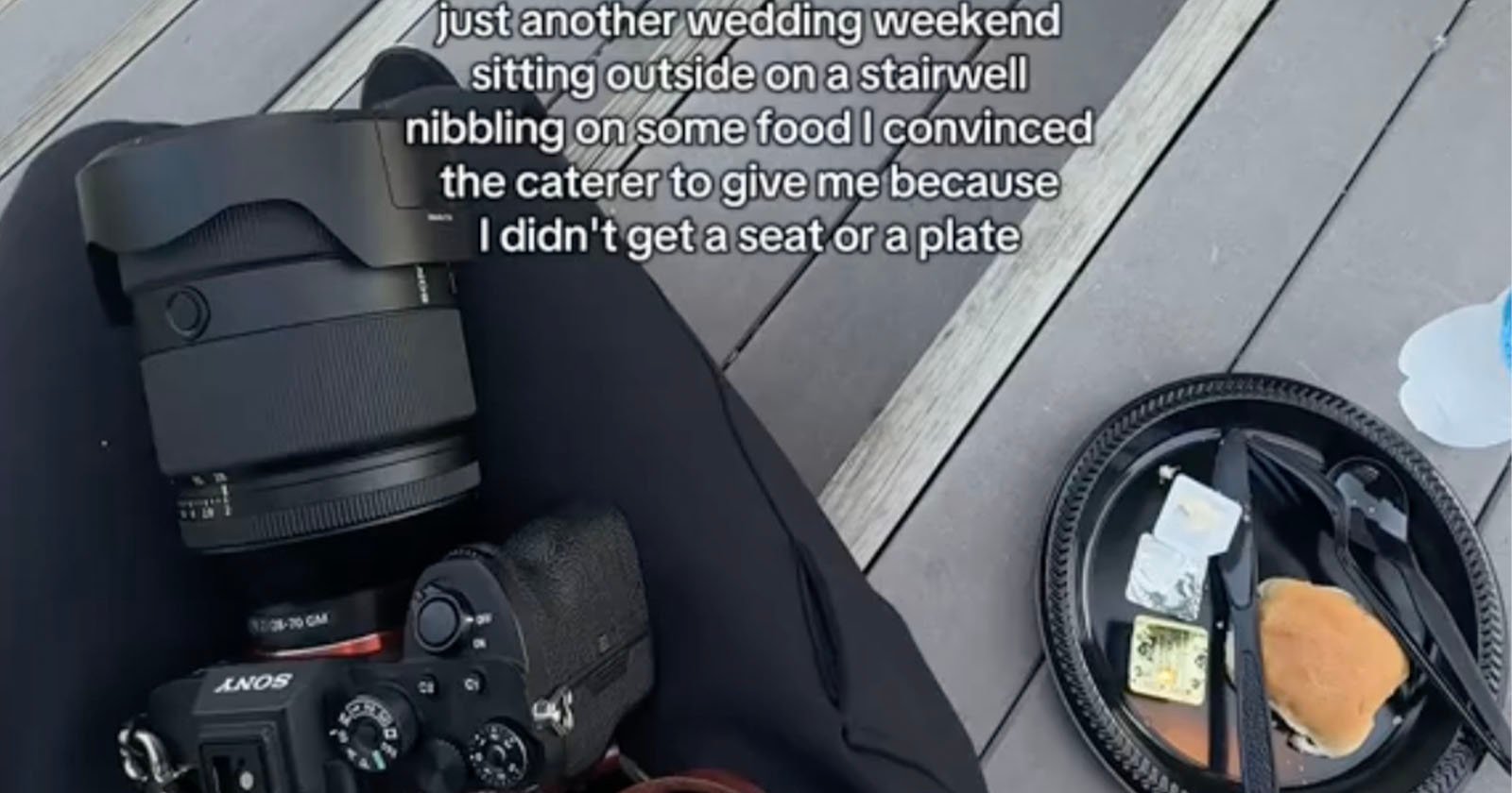 A person with a camera and lens on their lap sits on outdoor steps next to a disposable plate with a half-eaten burger, cheese, and plastic cutlery. Text overlay describes their experience as a wedding photographer without a seat or plate.
