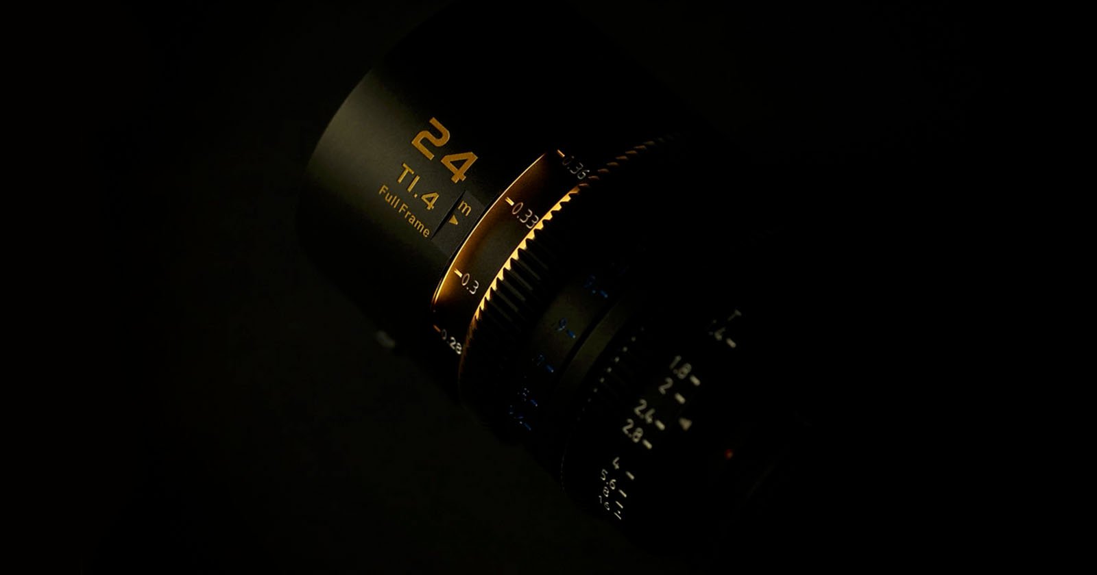 A close-up shot of a camera lens labeled “24 T1.4,” with gold lettering and numbers illuminated against a dark background. The focus is on the details of the lens' markings and textured rings.