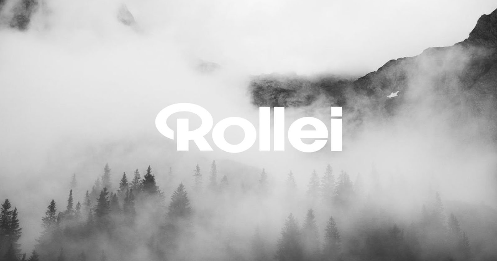 Foggy mountain landscape with dark pine trees in the foreground, rocky peaks in the background, and the word Rollei in bold white letters across the center.