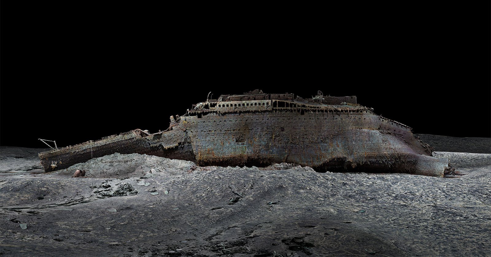A digitally rendered 3D model of the Titanic shipwreck, resting on the ocean floor. The ship’s structure is corroded and fragmented, with a dark, deep-sea backdrop highlighting its haunting state.