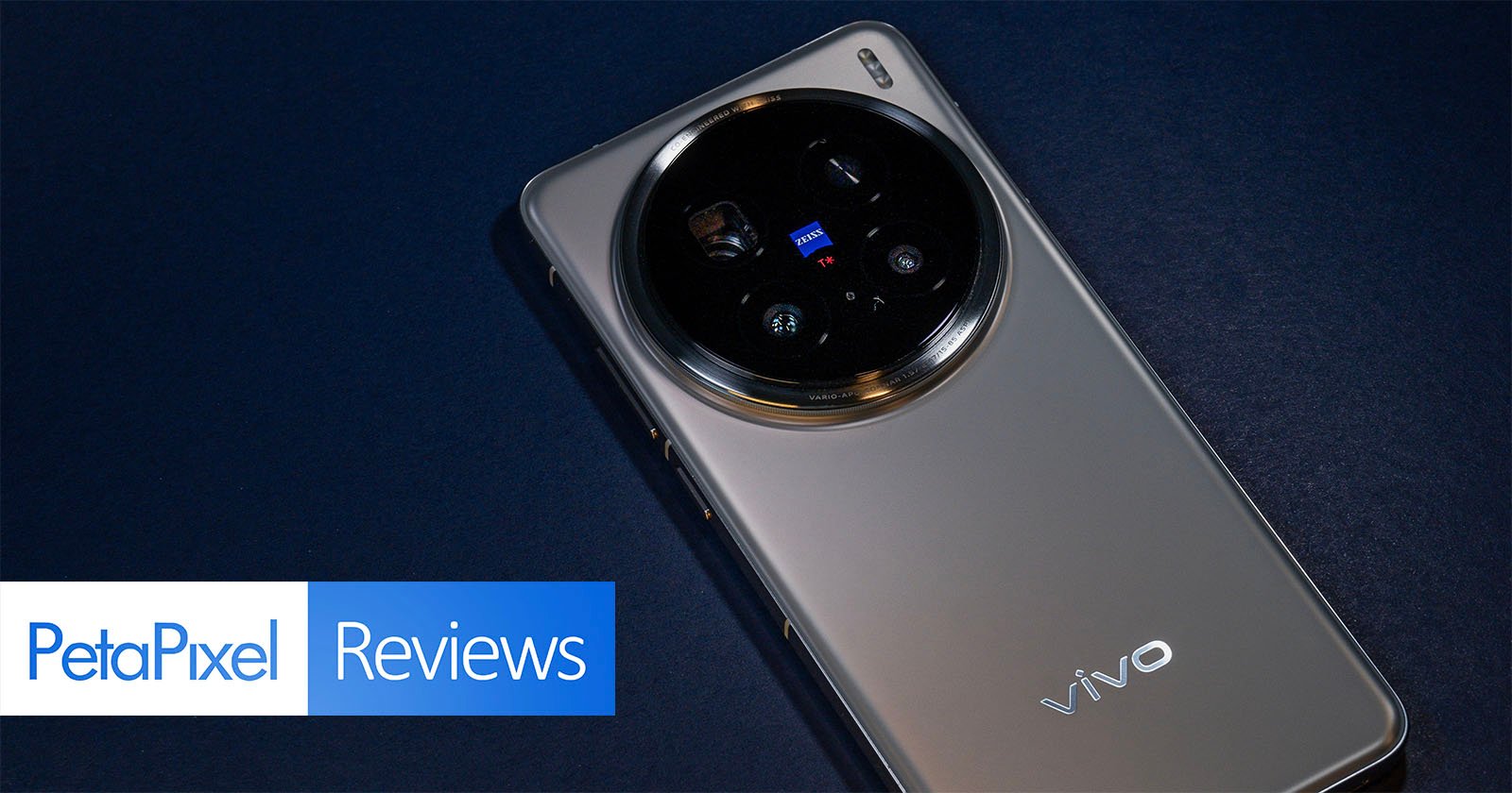 Smartphone with a large circular camera module on a dark surface. The phone has a metallic finish and displays the brand vivo. PetaPixel Reviews logo is visible in the bottom left corner.
