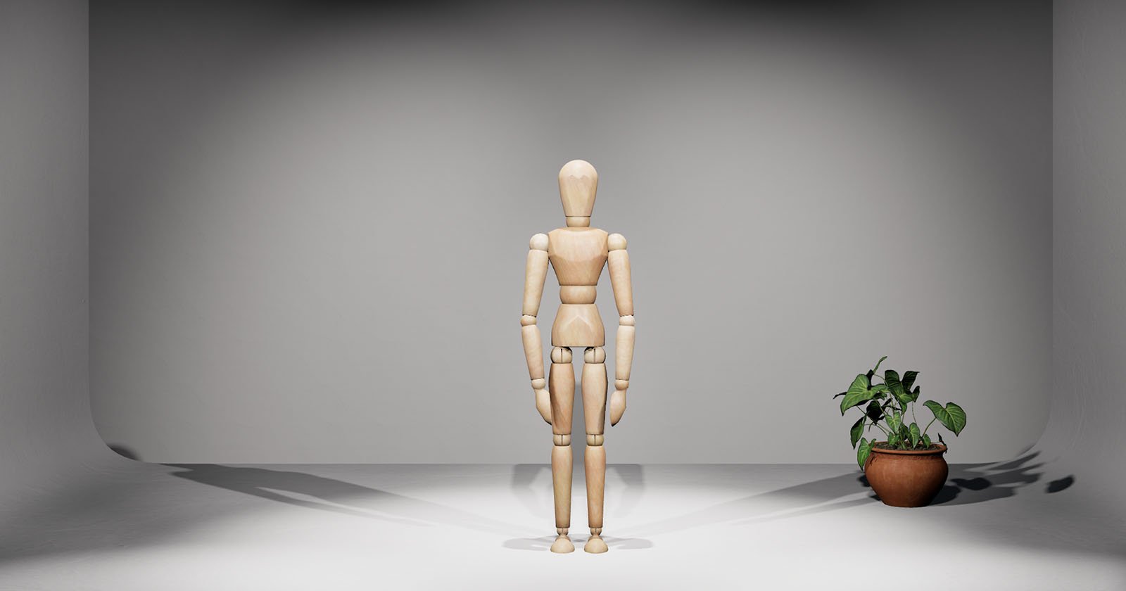 A wooden artist's mannequin stands in the center of a well-lit room, casting a shadow behind it. To the right, there is a small potted plant. The background is plain and neutral.