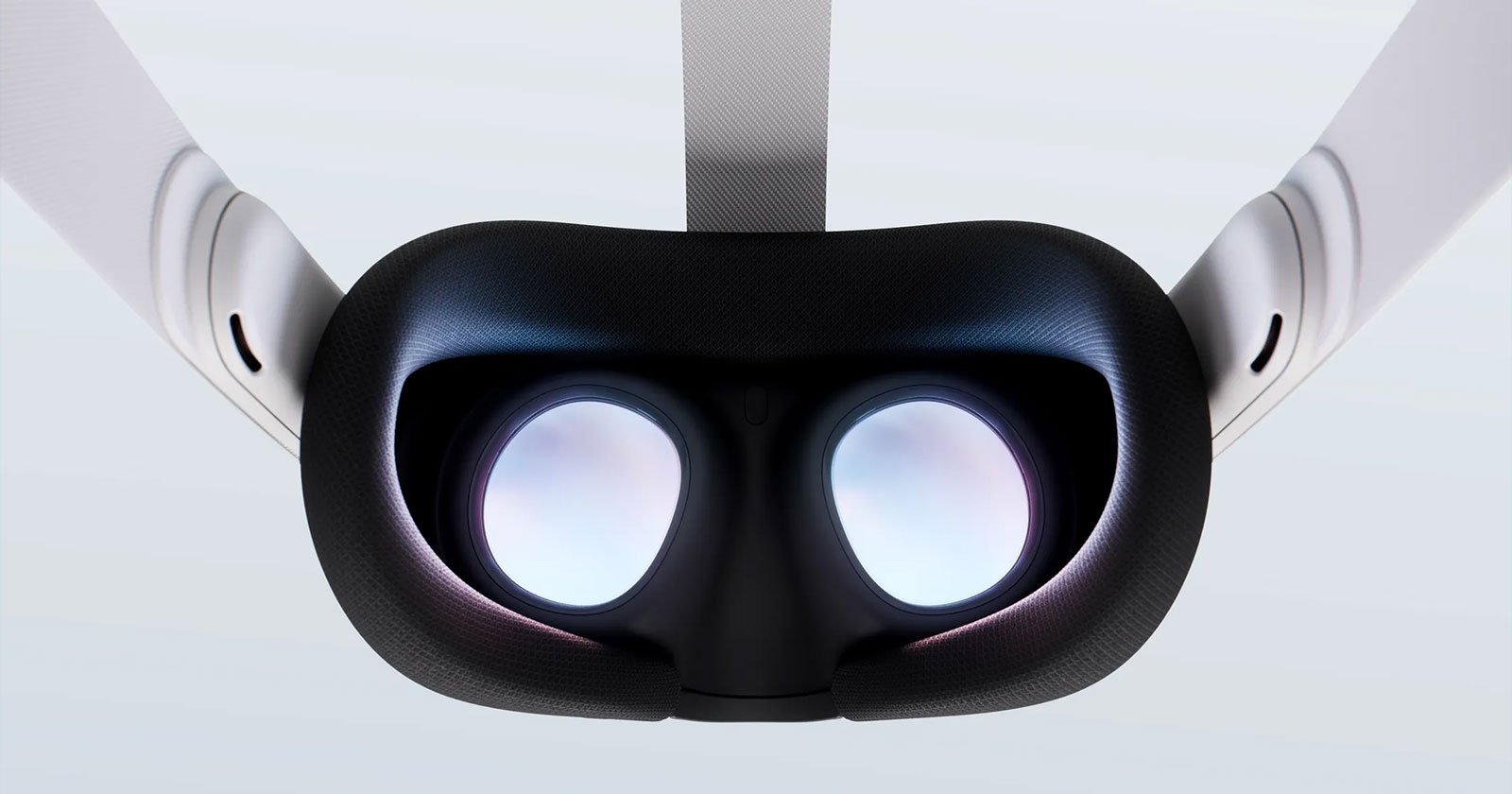 Close-up view of the inside of a virtual reality headset, showing the two lenses and head strap against a light background. The headset is predominantly black with some white elements.
