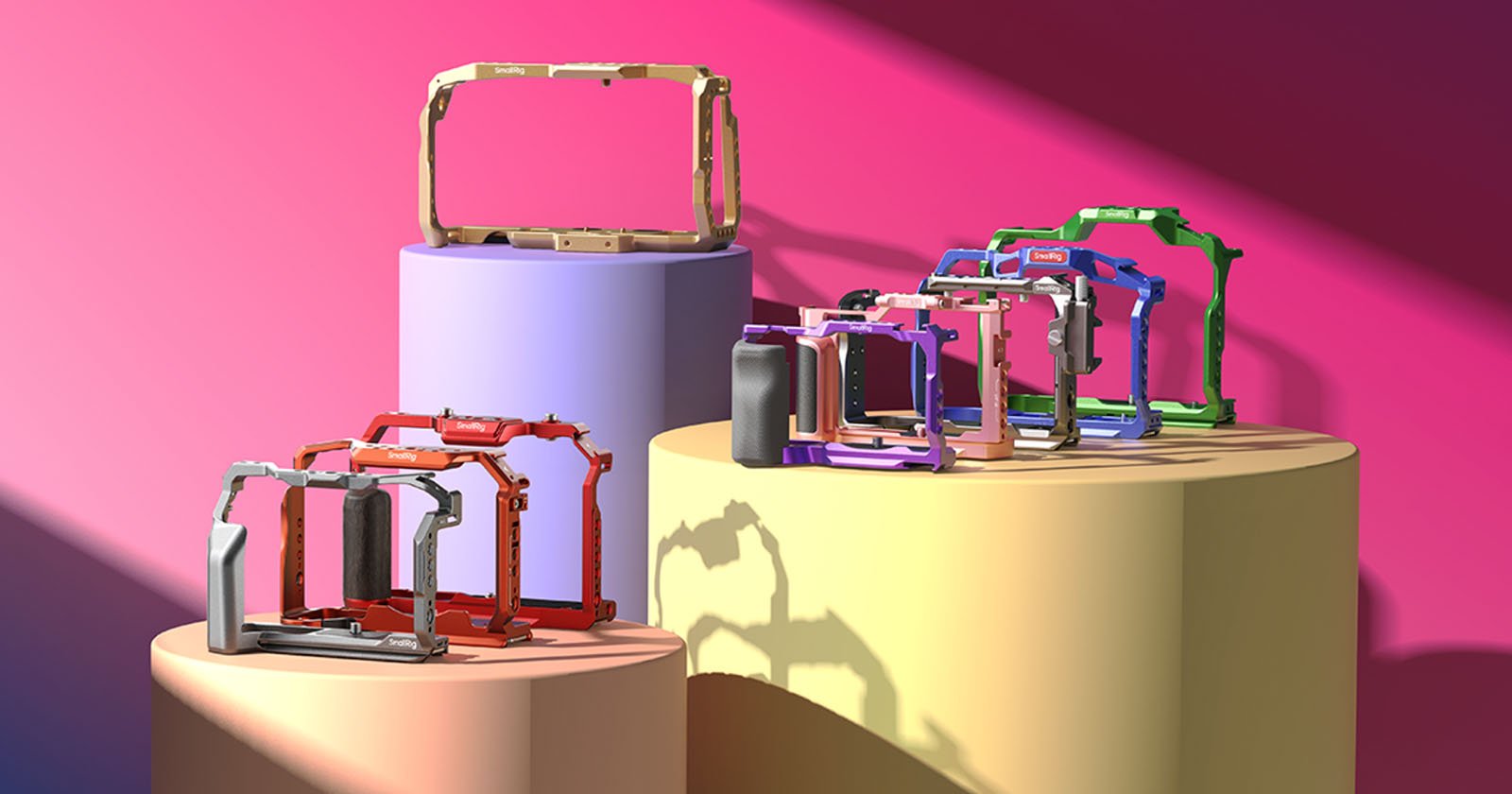 A collection of colorful open-frame computer cases are displayed on cylindrical pedestals against a gradient pink and purple background. The cases come in various colors, including red, blue, purple, green, black, and white, showcasing different design styles.