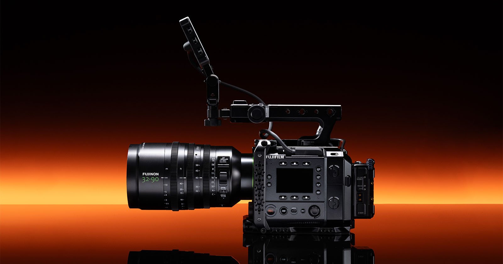 A professional Fujifilm digital cinema camera with a large Fujinon lens and mounted monitor, set against a dramatic black and orange gradient background.