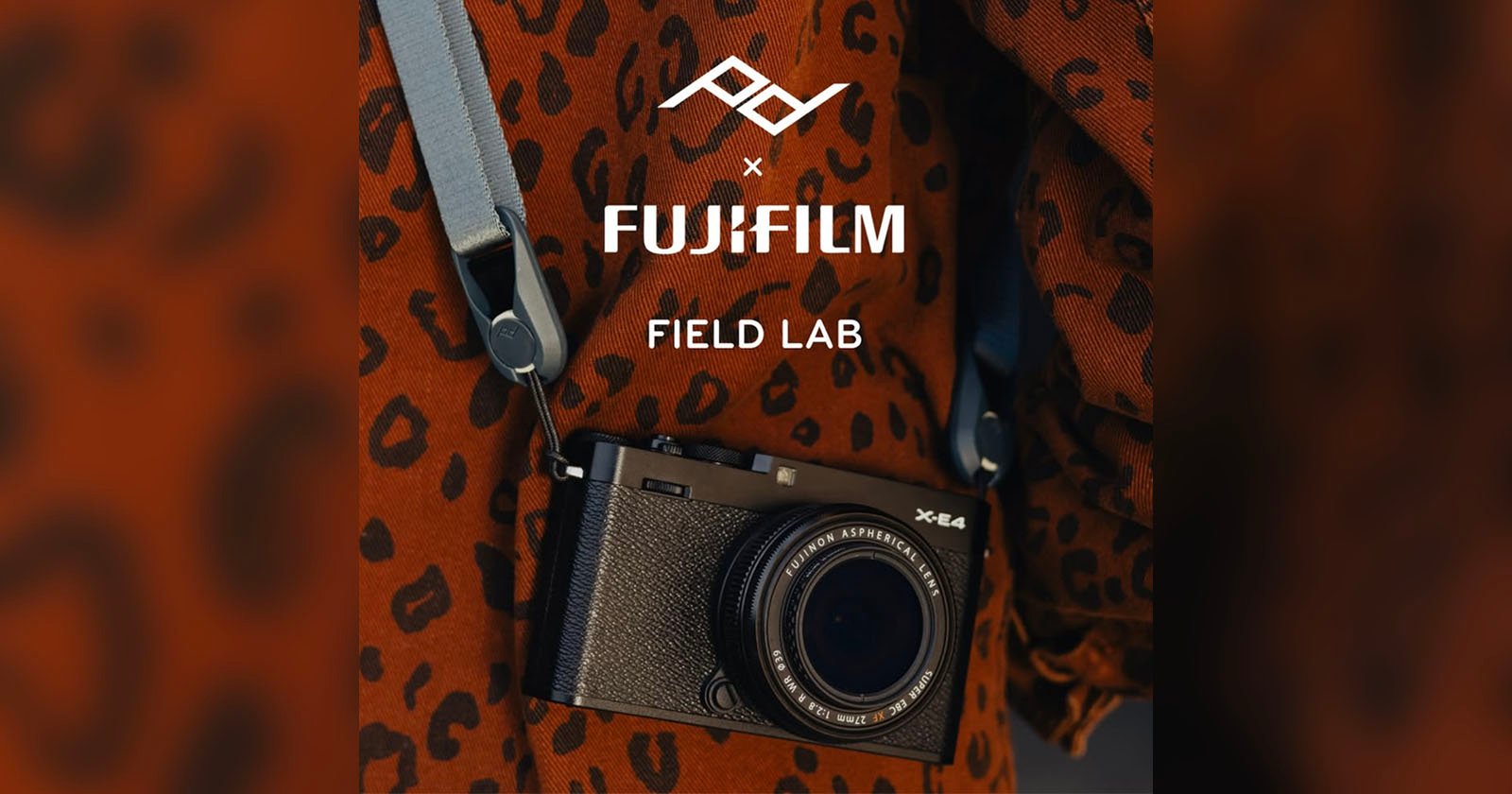 A Fujifilm X-E4 camera with a blue strap hangs against a brown, leopard-print fabric background. The text above reads FUJIFILM FIELD LAB with a geometric logo.