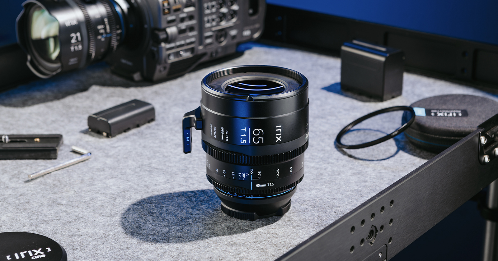 The Irix Cine 65mm T1.5 on a table with other cinematography essentials.