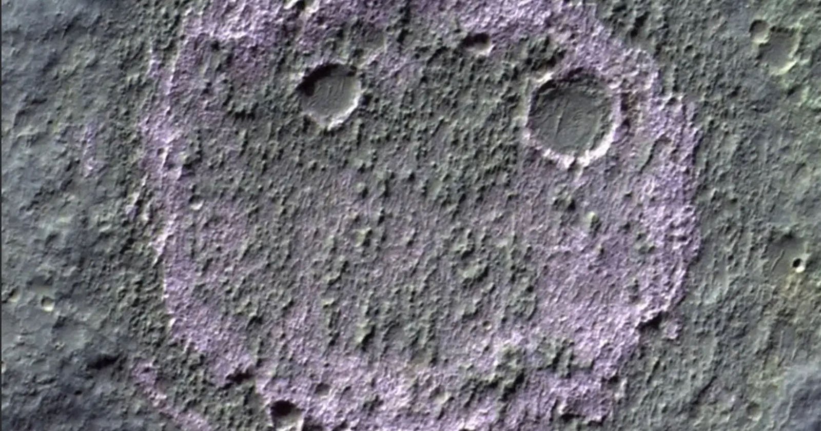 Aerial view of a cratered section of the Martian surface, where three distinct craters form a pattern resembling a smiling face. The eyes are two small circular craters, and the mouth is a larger, curved crater below them. The surface shows textured terrain.