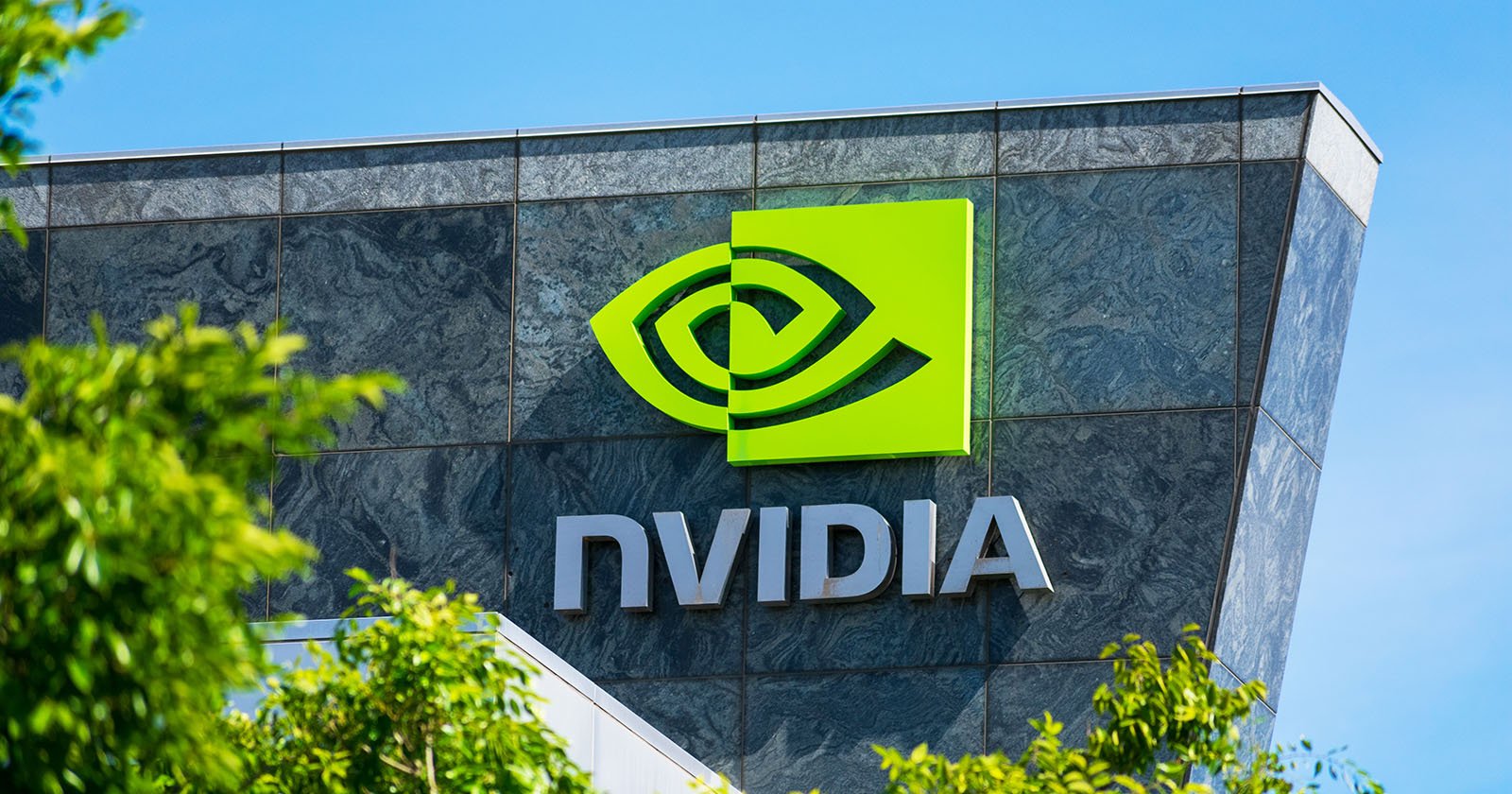 Nvidia logo and sign on headquarters. Blurred foreground with green trees. California.