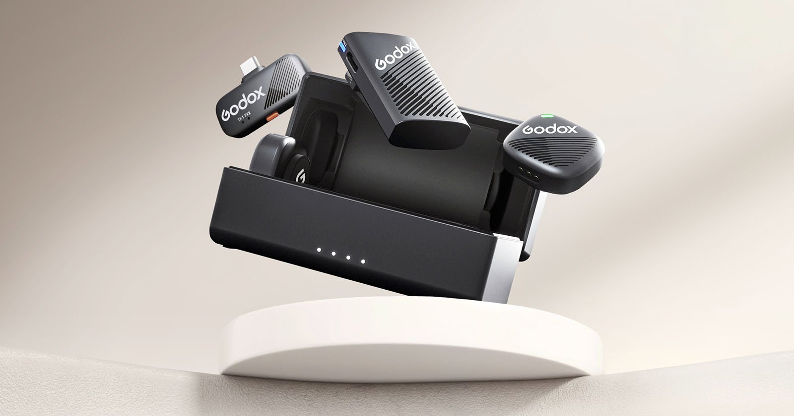 A Godox wireless microphone system with a charging case showcased on a round white platform. The microphones and case feature sleek black designs with the Godox logo. The background is a soft gradient of light beige tones.