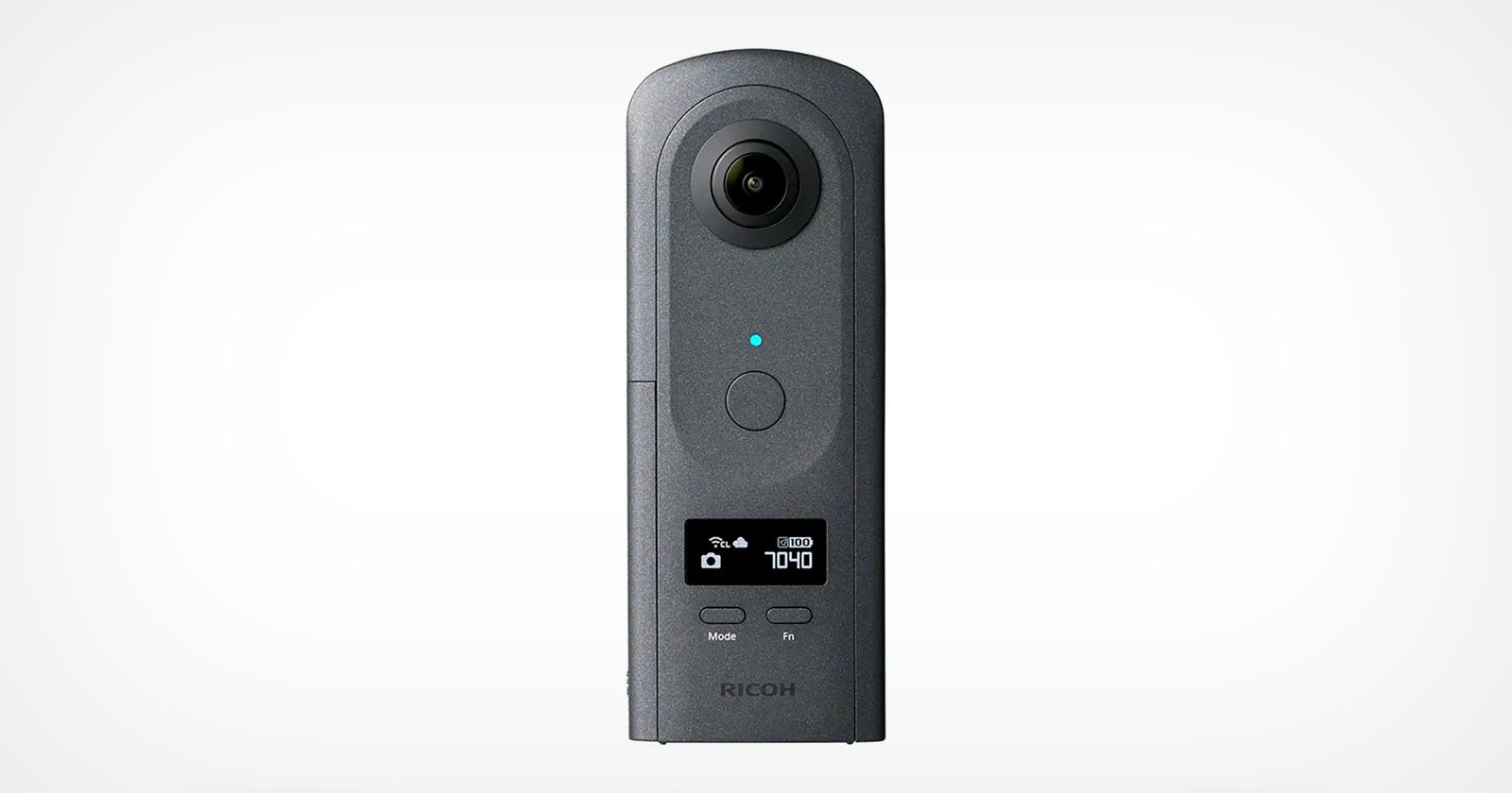 A black Ricoh Theta 360-degree camera stands upright against a plain white background, featuring a circular lens at the top, a blue indicator light, control buttons, and a small digital display on its front.