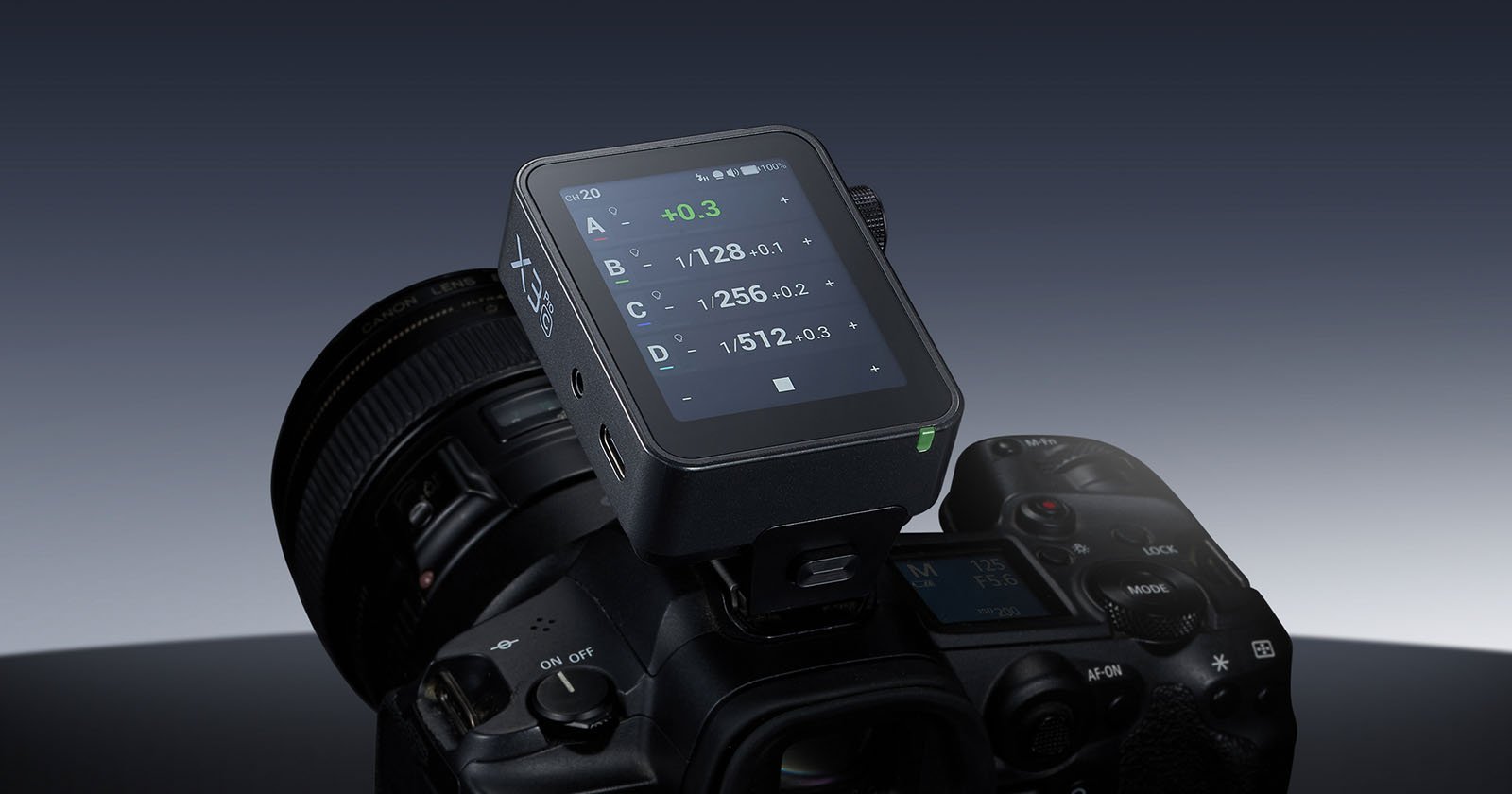 A digital camera with an attached external device displaying exposure settings on a small screen, placed on top of the camera near the lens and viewfinder.