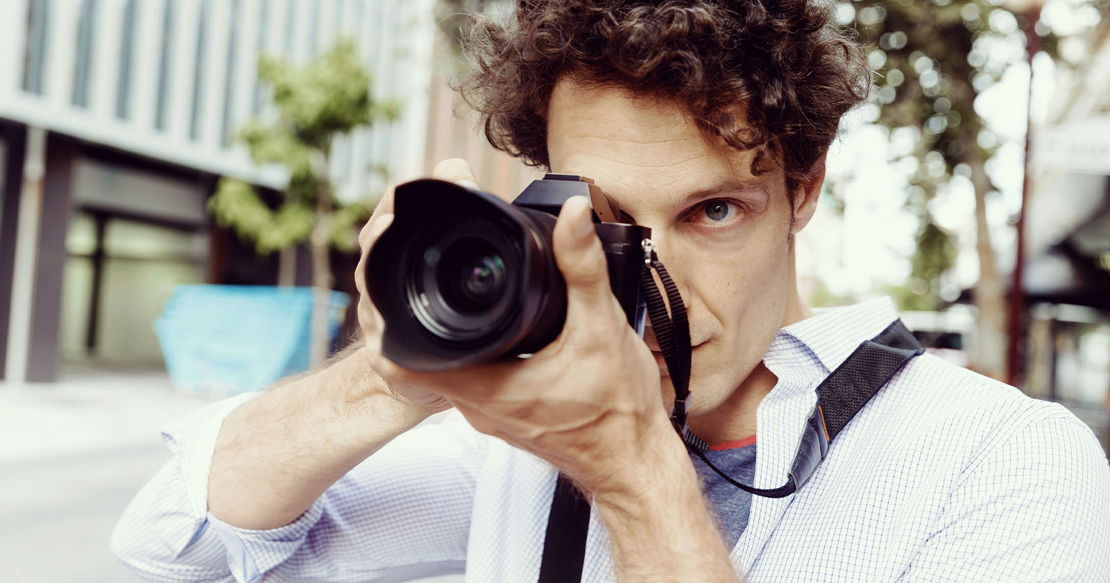 A man is seen taking a photo outside.