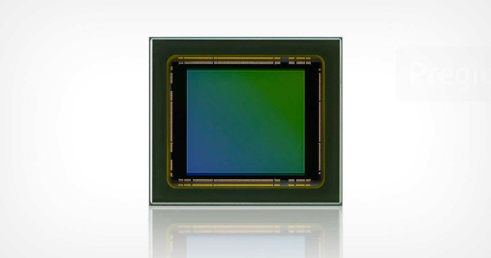 Close-up of a square electronic sensor chip with a green and blue gradient in the center, bordered by a metallic frame, set against a plain white background.