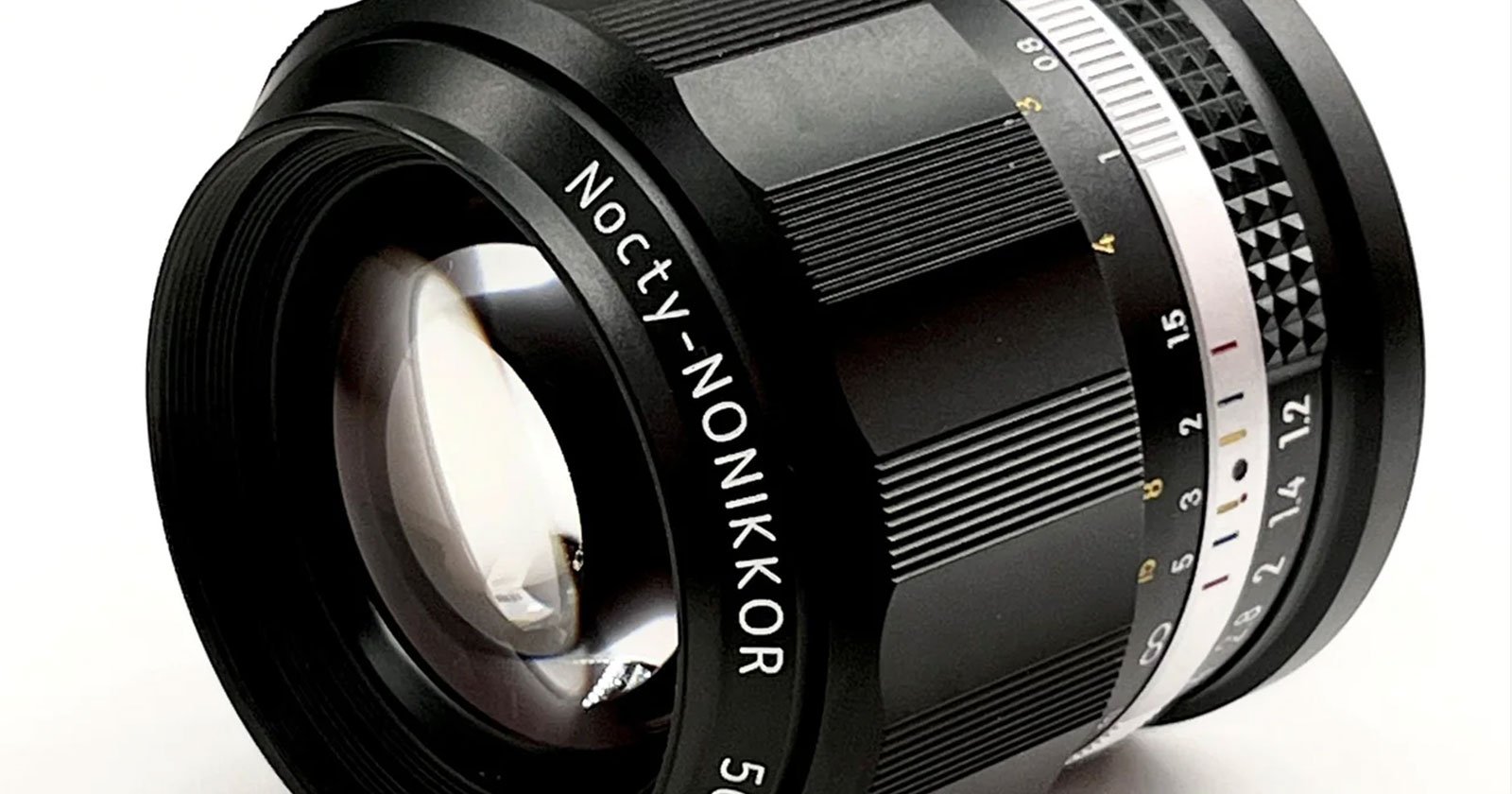 A camera lens labeled Nocty-NONIKKOR 5 with a large reflective front element. The lens features a focus ring with ridged texture for grip and an aperture ring marked with f-stops from f/1.2 to f/16. The lens is shown on a plain white background.