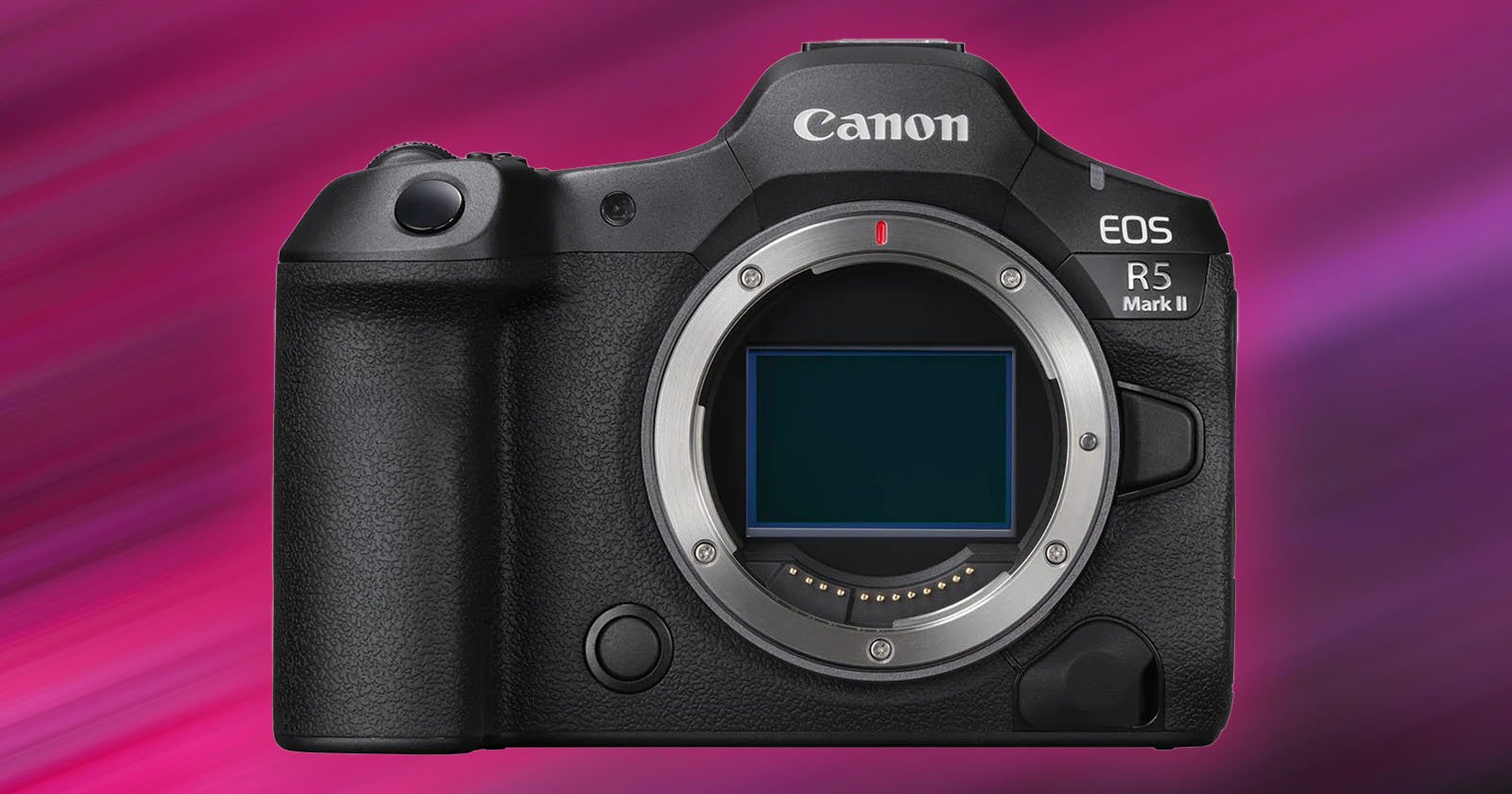 A Canon EOS R5 Mark II camera without a lens, showcasing the camera body and sensor. It has a textured grip on the left and various buttons on the top and front. The background features a gradient of pink and purple hues.