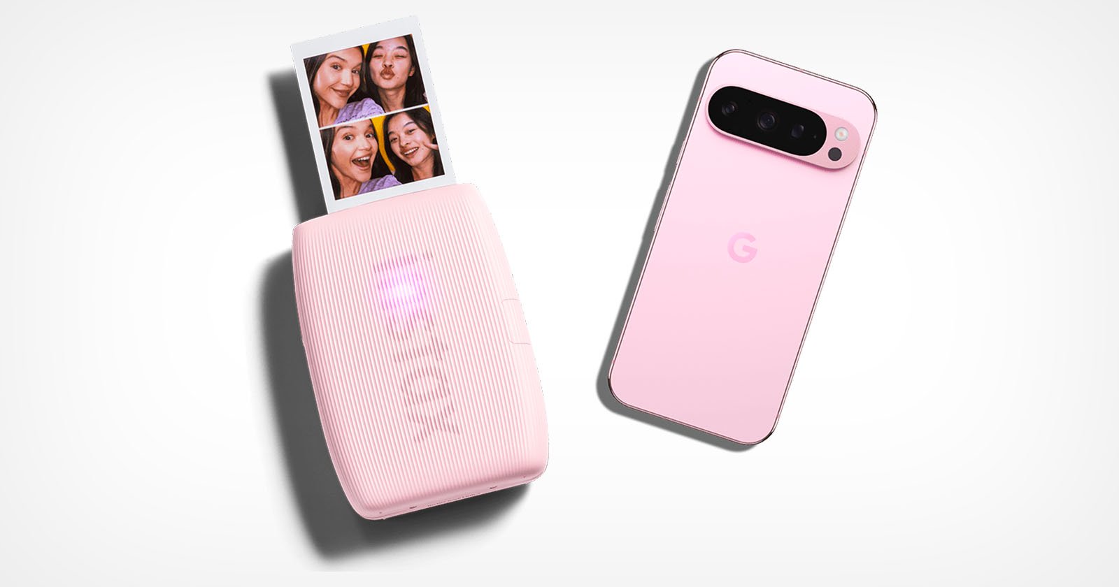 A pink smartphone with a G logo lies next to a compact pink photo printer. The printer is producing a strip of photo booth–style images featuring smiling faces. Both devices are set against a white background.