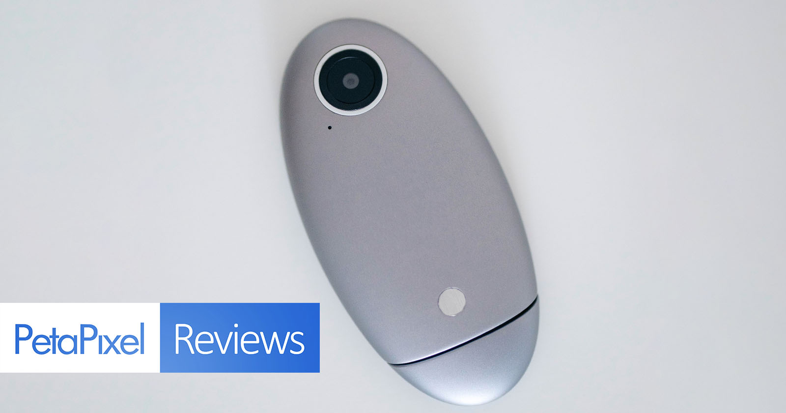 A silver, oval-shaped camera device with a lens at one end is placed on a white surface. In the bottom left corner, there is a PetaPixel Reviews logo.
