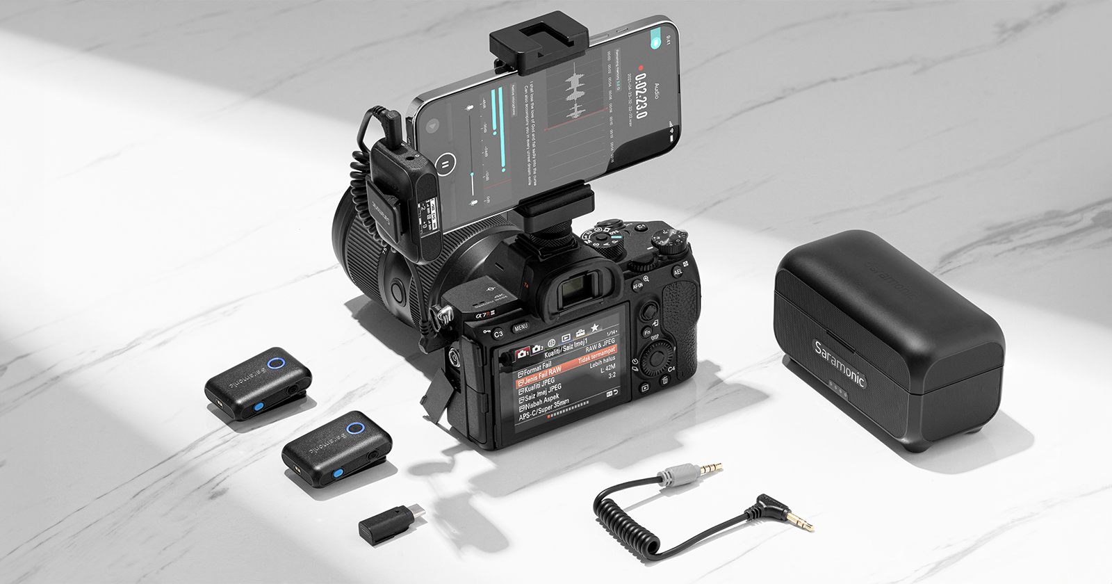 The Saramonic Blink500 B2+ mic system is attached to a camera, which sits on a white surface.
