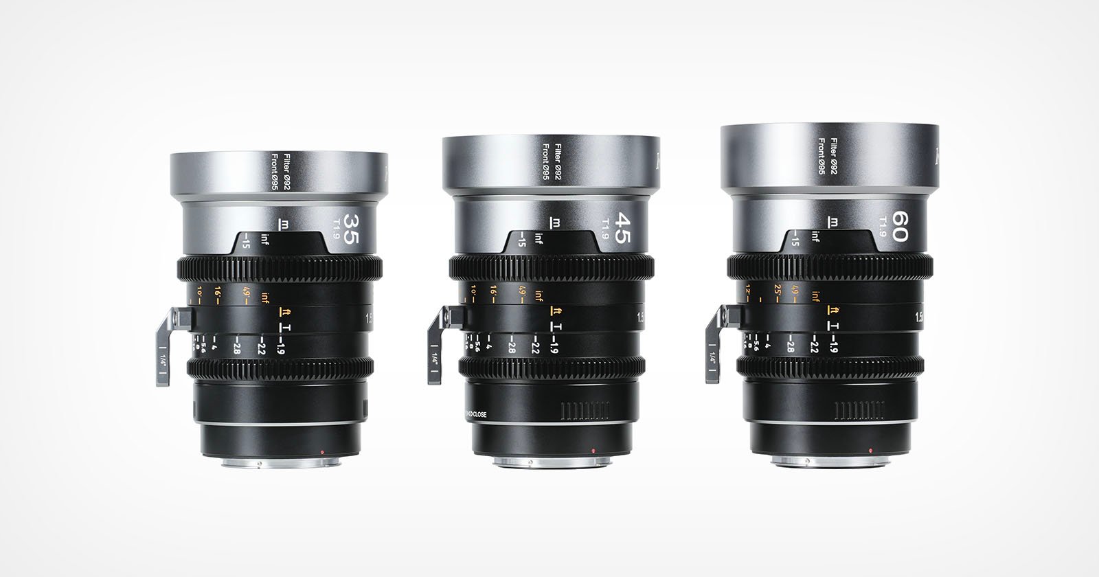 Three professional camera lenses with focal lengths of 35mm, 45mm, and 60mm are displayed upright side by side against a white background. The lenses feature focus and aperture rings with labeled markings.