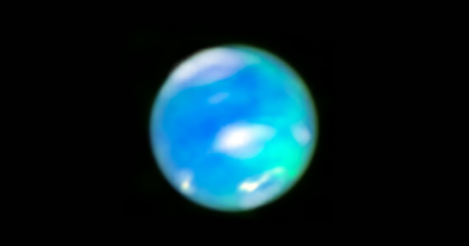 A blurry, spherical object with blue and green hues set against a black background, resembling an abstract representation of a planet.