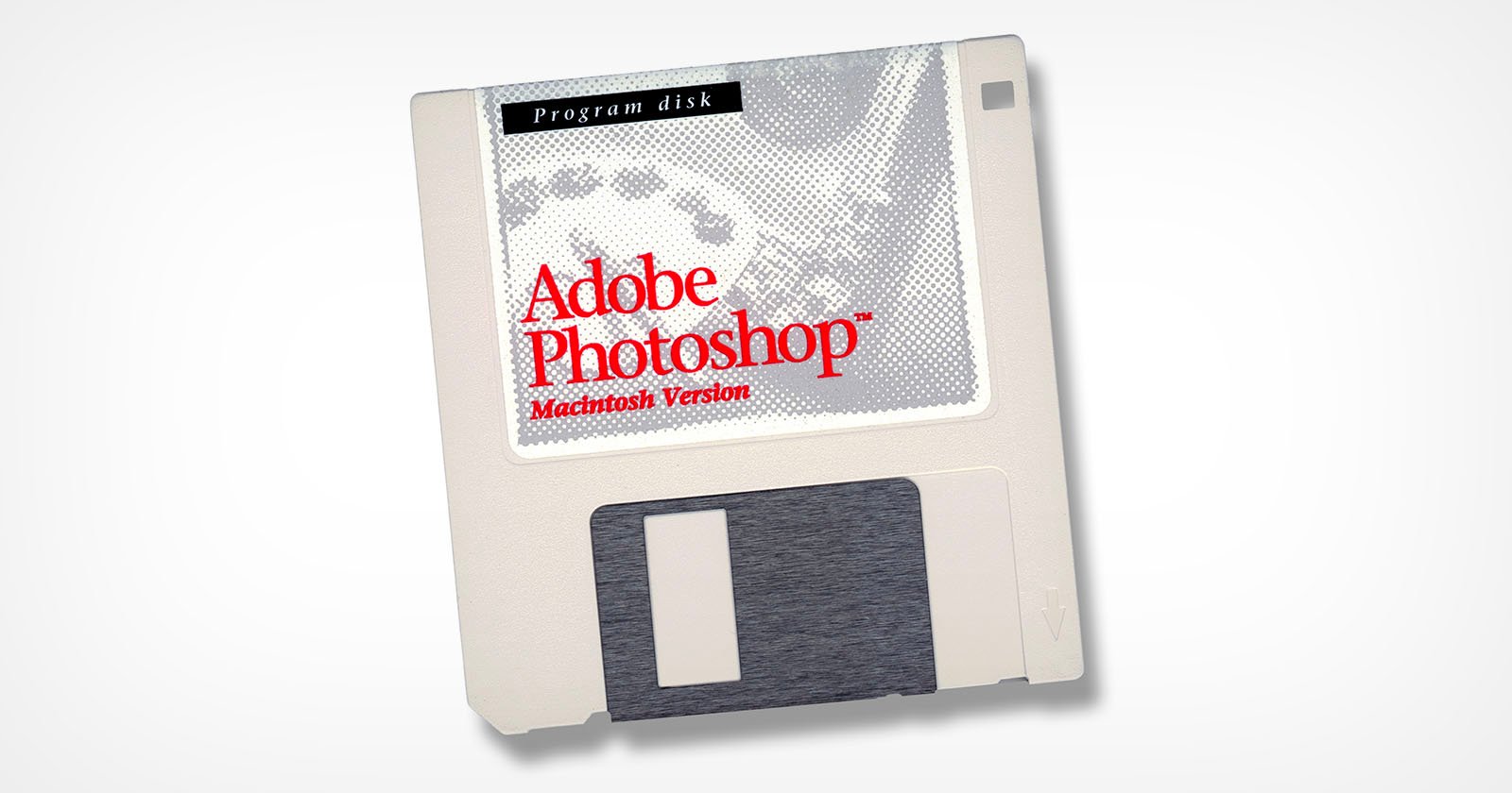 A vintage Adobe Photoshop floppy disk for the Macintosh, featuring a gray and white label with Adobe Photoshop and Macintosh Version written in red and black text. The disk shows a partial image of a grayscale photo on the label.