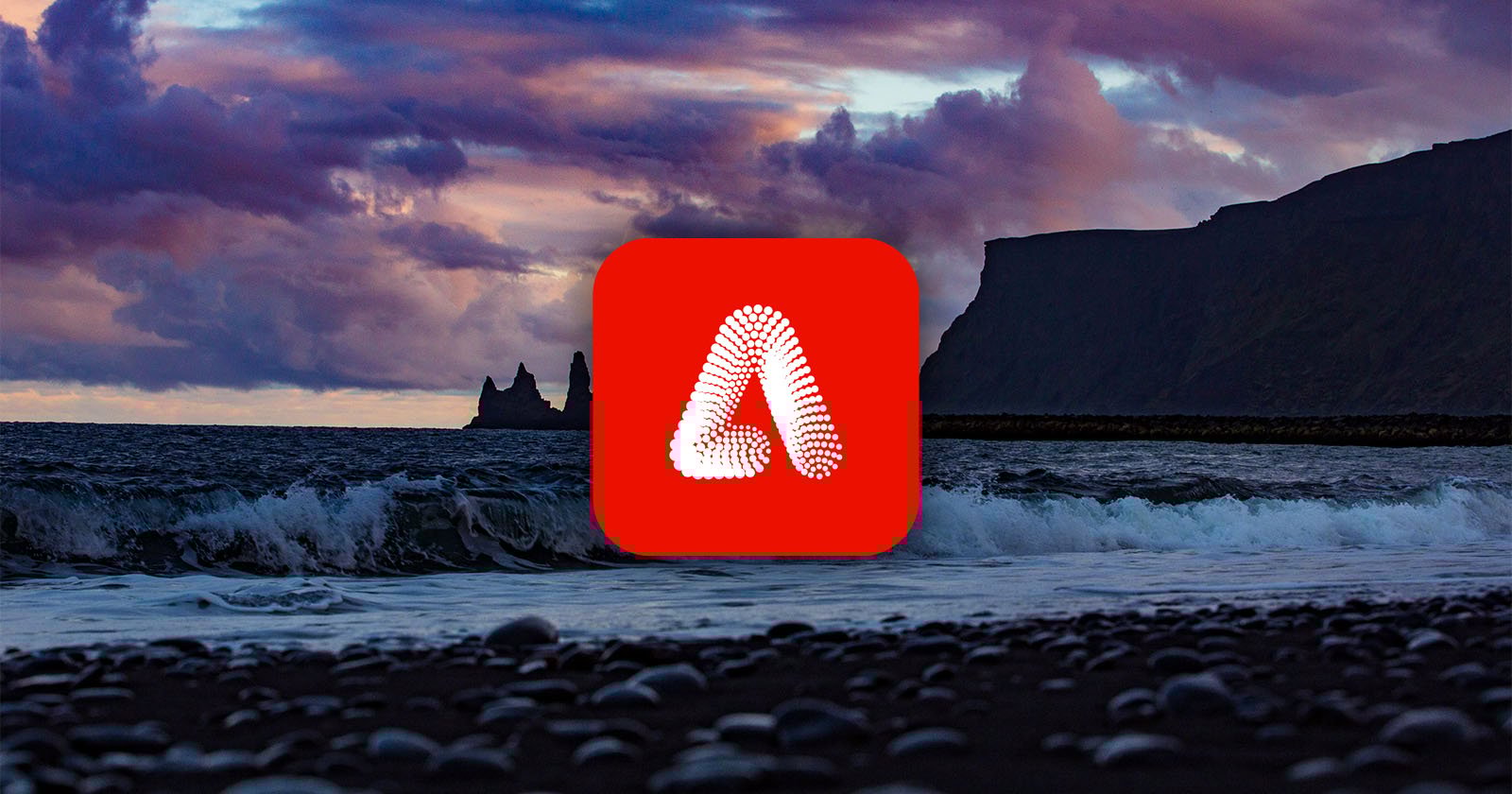 A logo with a red background and a stylized white letter A in the center overlays a scenic ocean view. Waves crash on a pebble beach under a dramatic, cloudy sky. Rocky cliffs are silhouetted in the background.