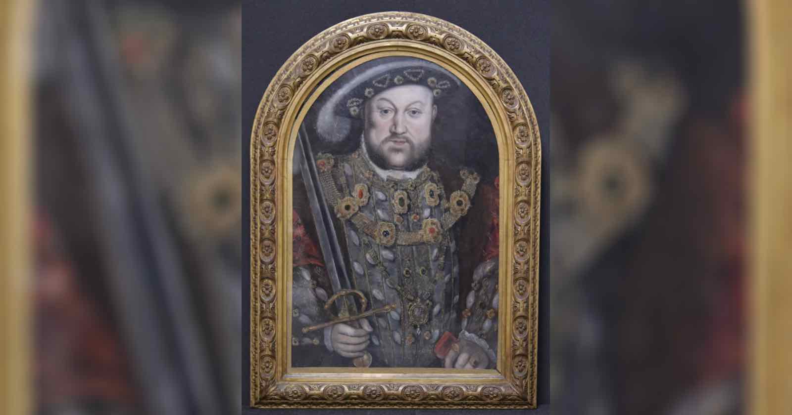 A framed painting of a man in ornate Tudor-era clothing, wearing a hat and holding a sword. The detailed gold frame is arched, and the background is dark, highlighting the subject’s elaborate jewelry and attire.