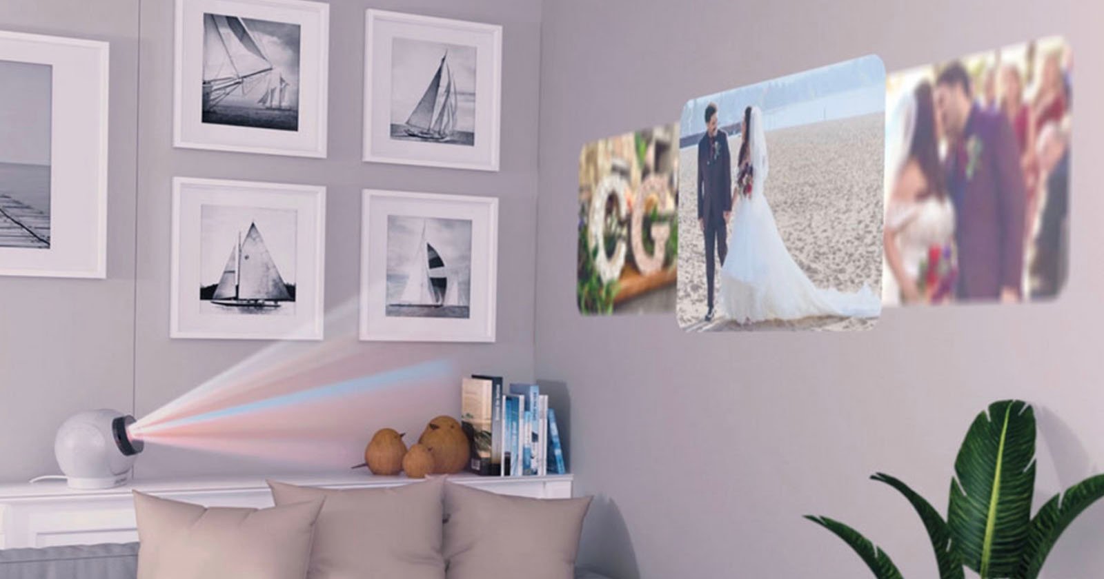 A projector sits on a side table, projecting wedding and couple photos onto a wall above a sofa, which is decorated with framed sailboat pictures and a green plant nearby.