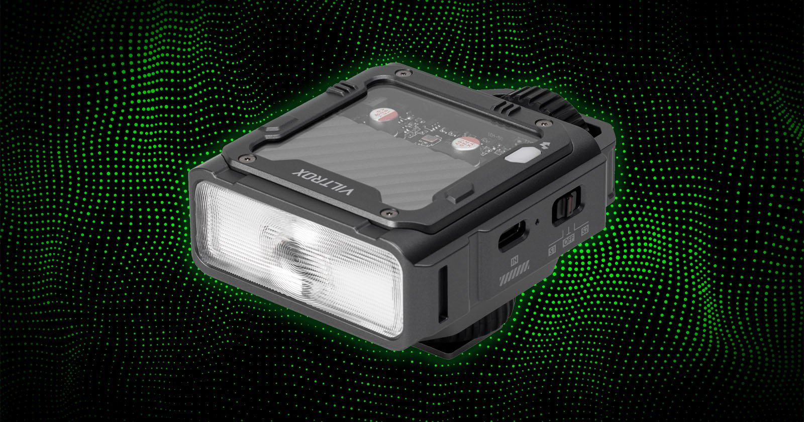 A compact, rectangular LED device labeled VILTROX, shown against a black background with green dotted waves. The device has a translucent front light panel and visible buttons and ports on the sides.