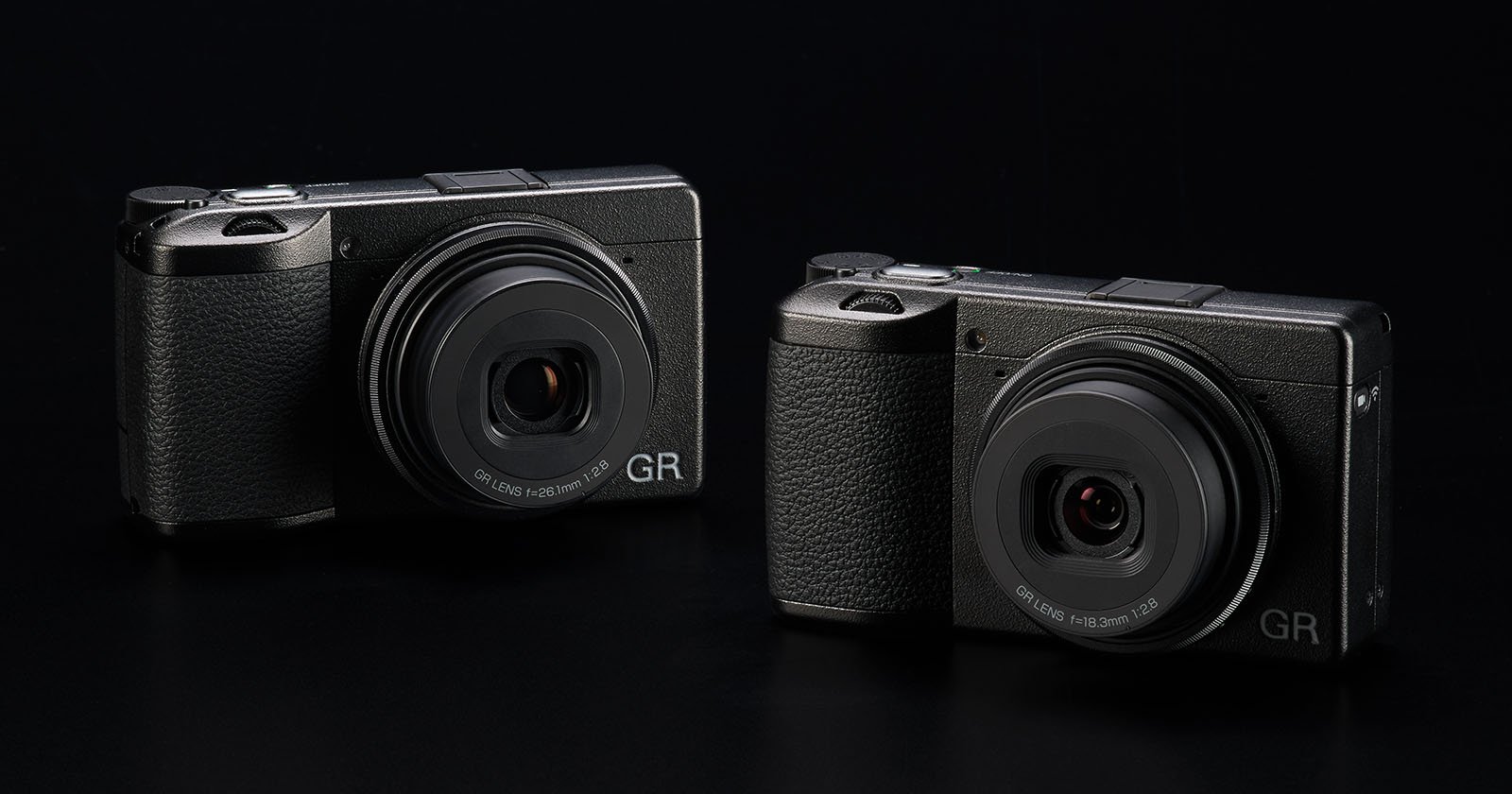 Two Ricoh GR series compact digital cameras are displayed against a black background. Both cameras have a sleek and minimalistic design, featuring prominent lenses and textured grips for easy handling. The branding GR is visible on the bottom right of each camera.