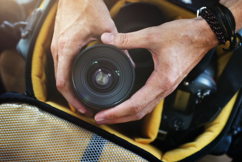 A photographer taking a lens out of a camera bag