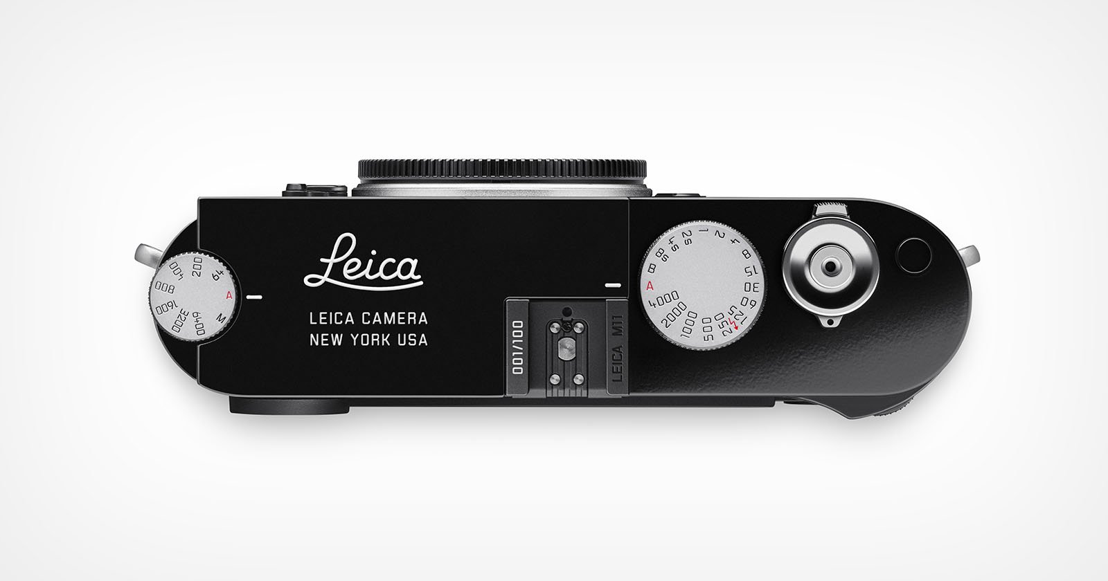 Top view of a black Leica camera, showing dials, buttons, and the lens mount; Leica Camera New York USA is printed on the body. The camera appears modern and sleek with a minimalist design.