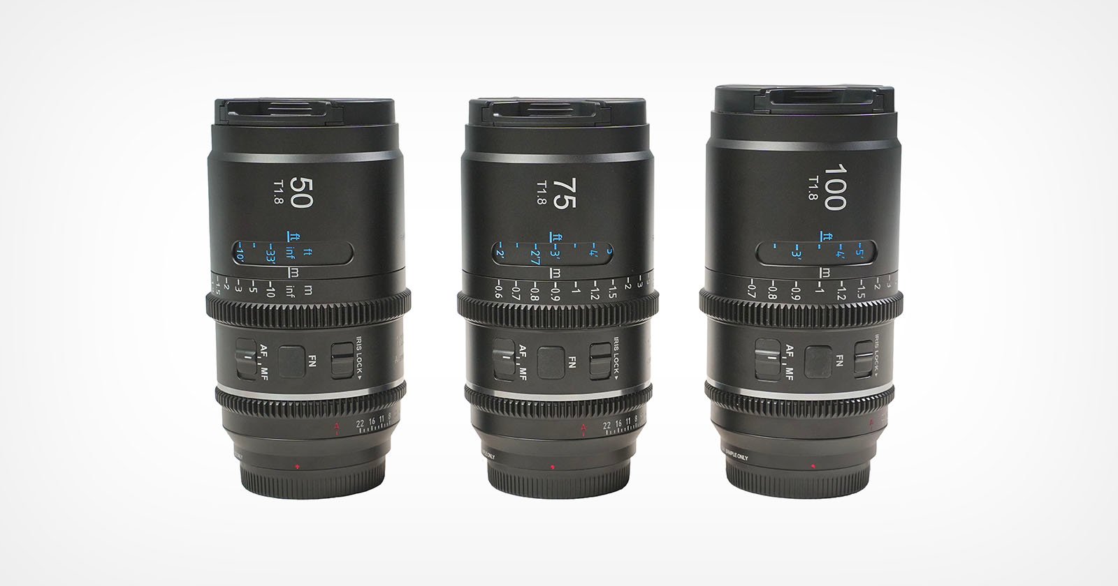 Three black camera lenses labeled 50mm, 75mm, and 100mm are standing upright in a row on a plain white background, showing detailed focus and aperture markings.