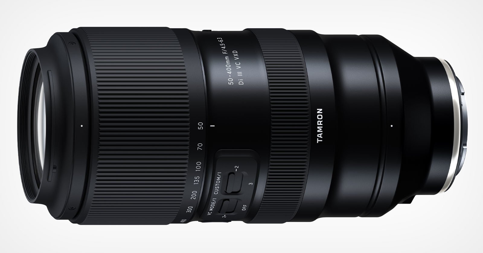 A black Tamron 50-400mm f/4.5-6.3 Di III VC VXD camera lens with various markings and settings visible on its body, including zoom and focus rings. The lens is positioned against a white background.