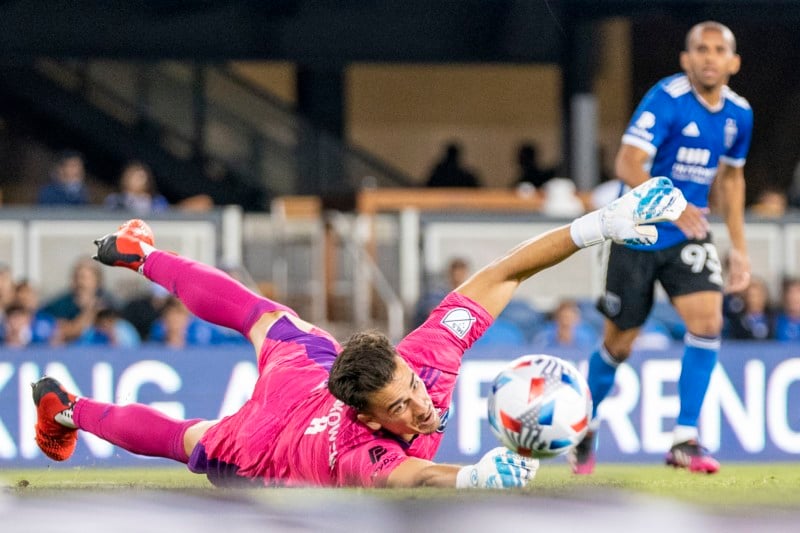 Soccer goalie attempting to block a shot