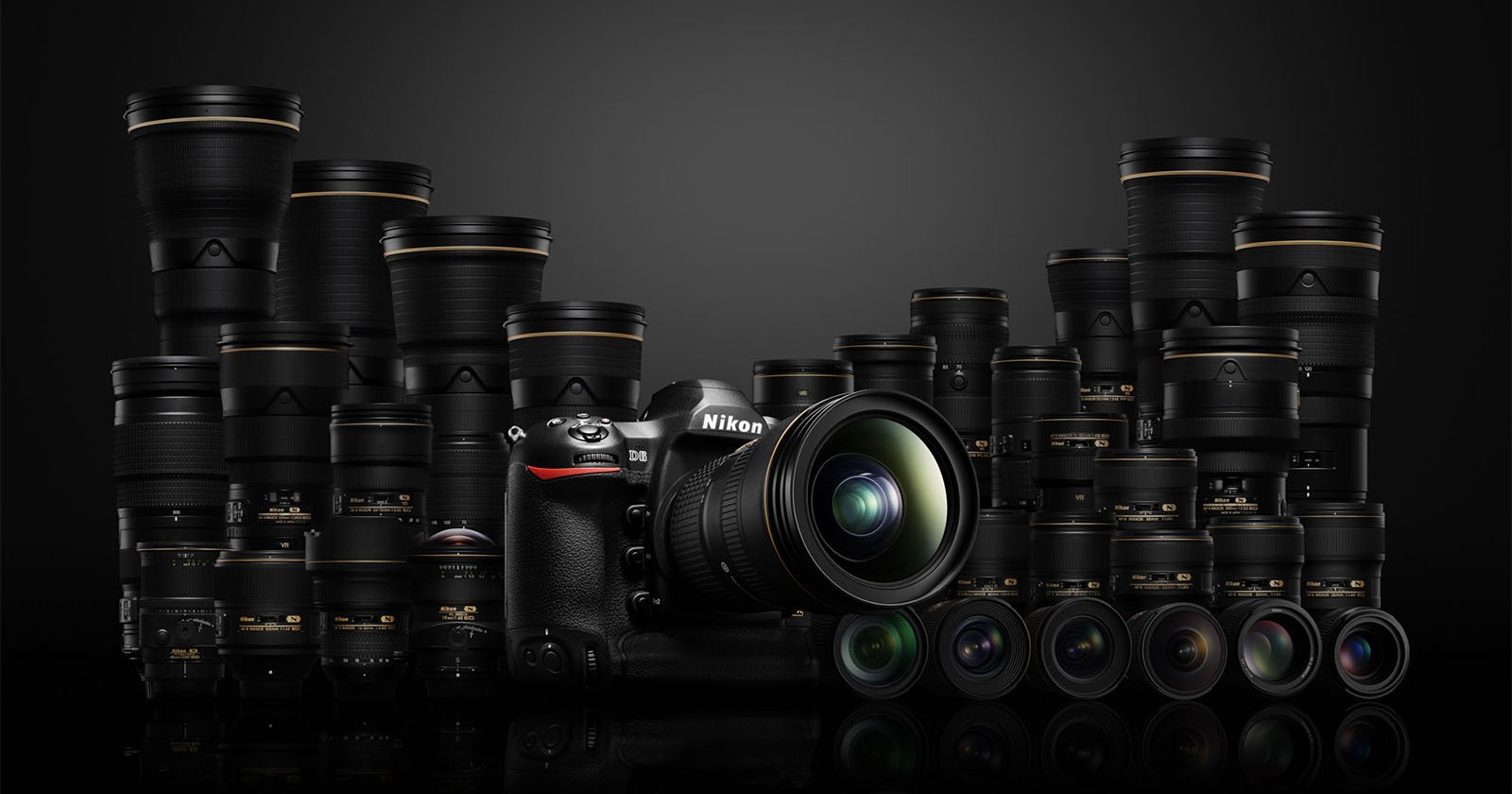 A Nikon DSLR camera with a lens attached is surrounded by multiple Nikon lenses of various sizes, all displayed against a dark background.