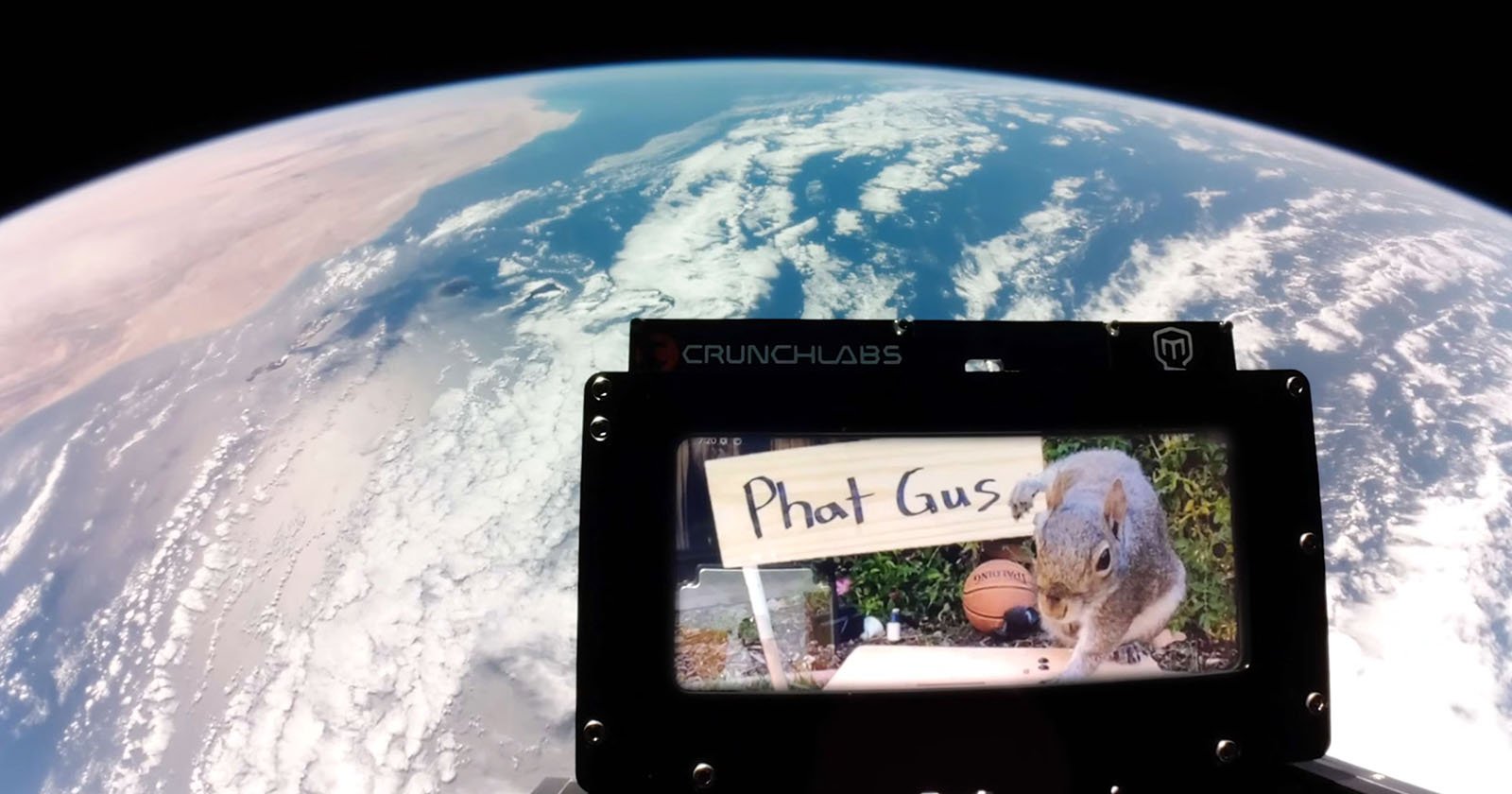 A view of Earth from space with a CrunchLabs frame in the foreground displaying an image of a squirrel next to a sign that says Phat Gus.