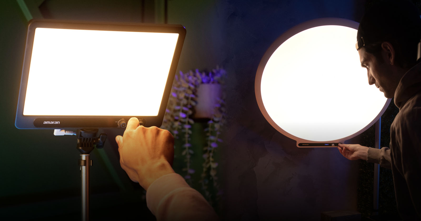 A person adjusts the brightness on a rectangular LED panel light and a round LED panel light, both mounted on stands, in a dimly lit studio setting.