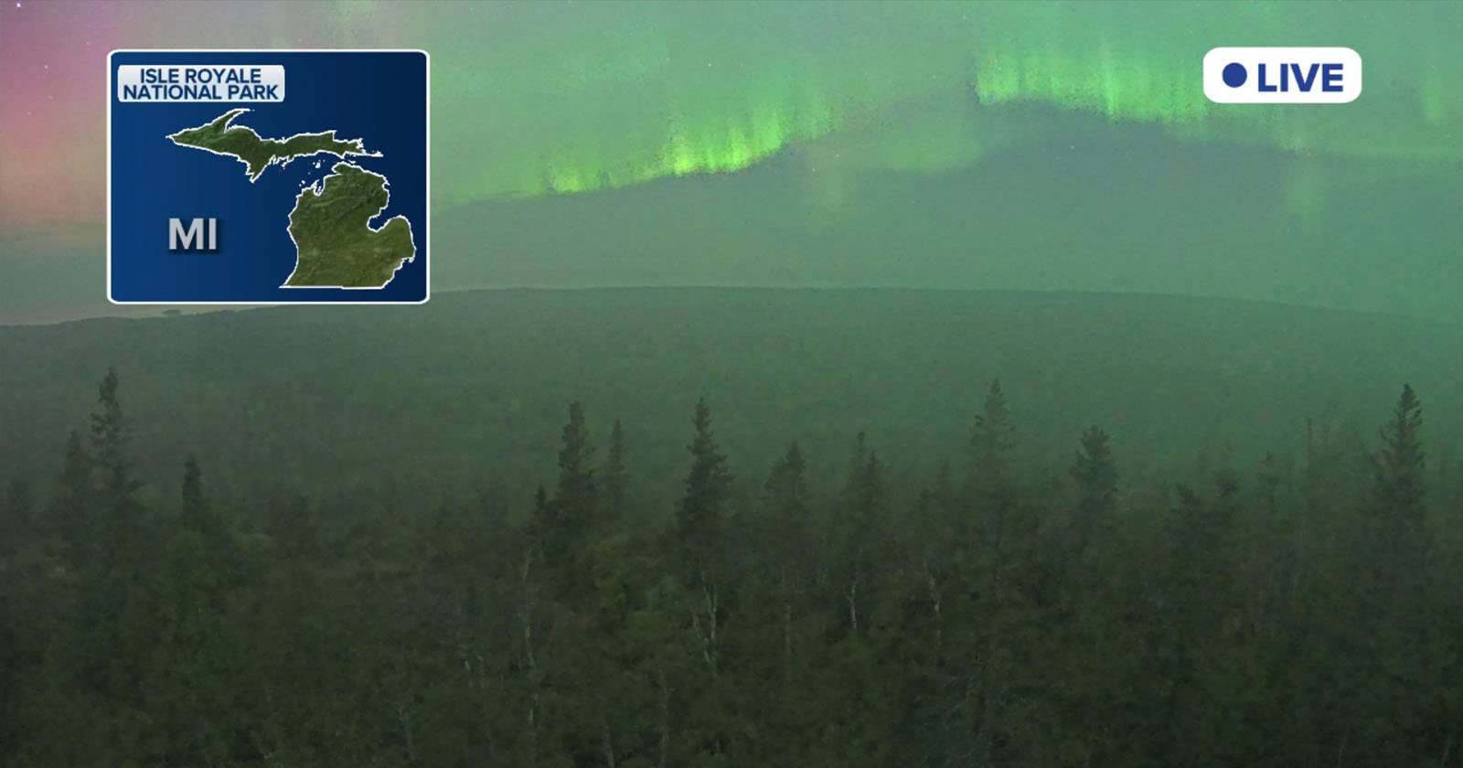 Northern lights glow green in the night sky above a forest at Isle Royale National Park, Michigan. An inset map shows the park's location in Michigan, with a LIVE indicator in the upper right corner.