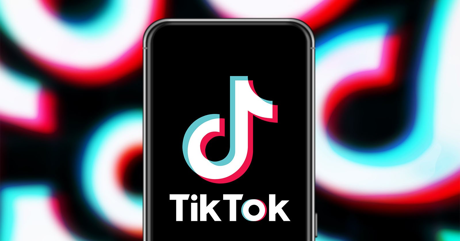 A smartphone displays the TikTok logo on its screen. The background features blurred and colorful versions of the same logo, creating a vibrant, dynamic effect. The TikTok logo consists of a musical note with cyan, pink, and white colors.
